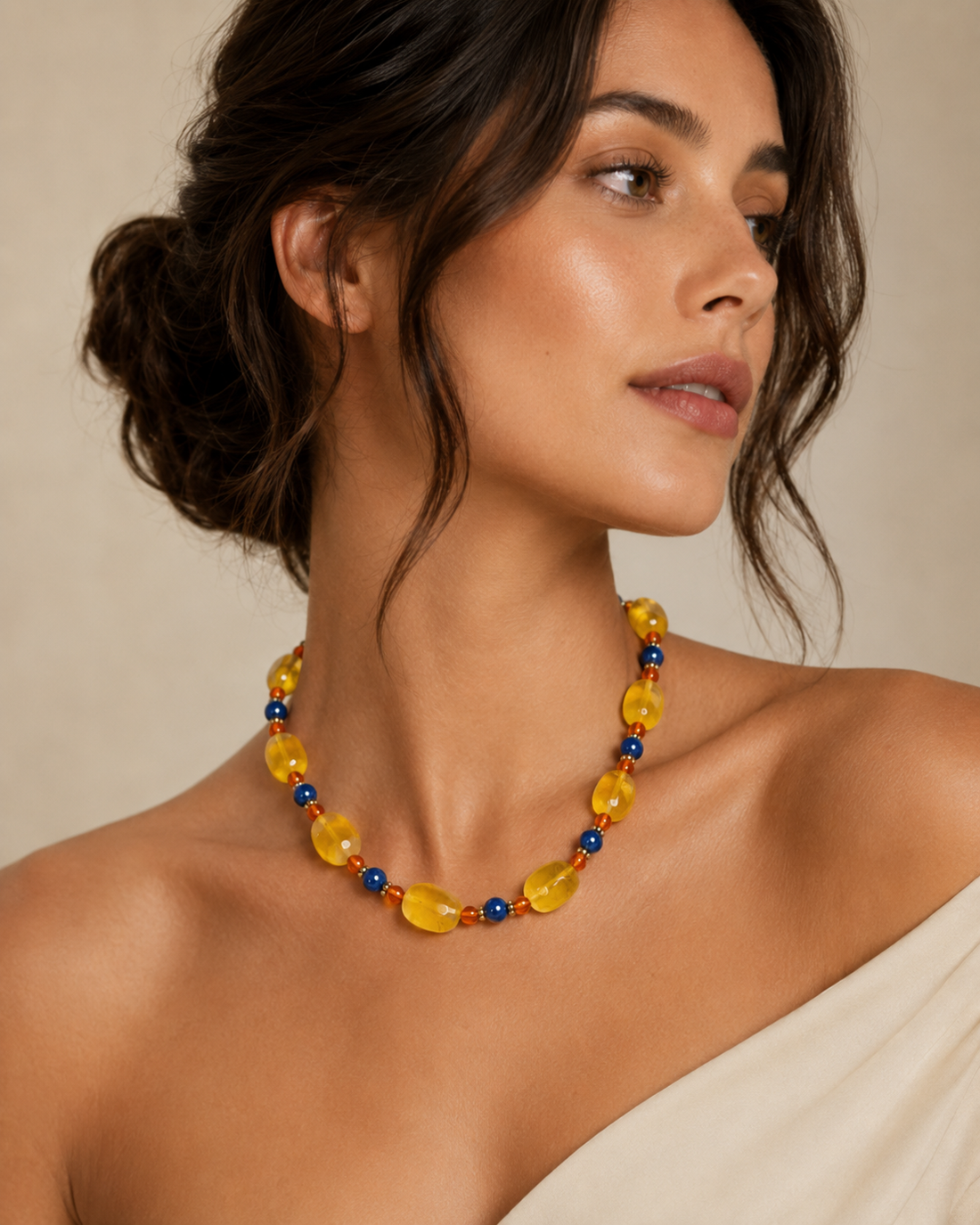 Woman wearing a colorful beaded necklace against a neutral background