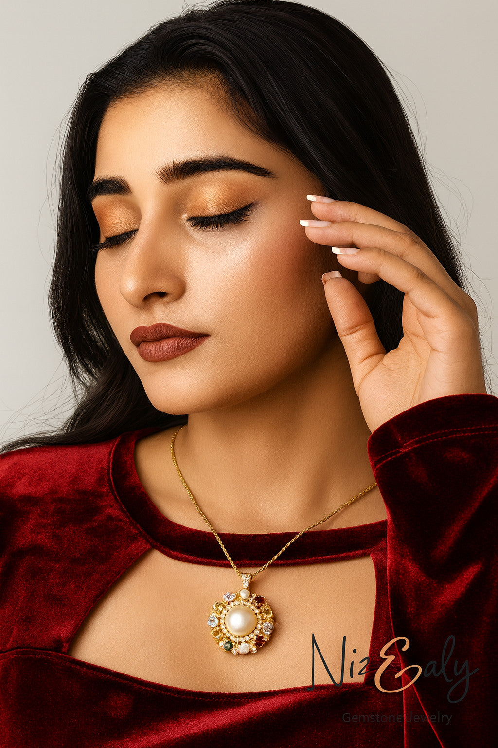 Model wearing a Niz & Aly gold-tone pendant necklace with a central pearl and multi-colored gemstone halo.
