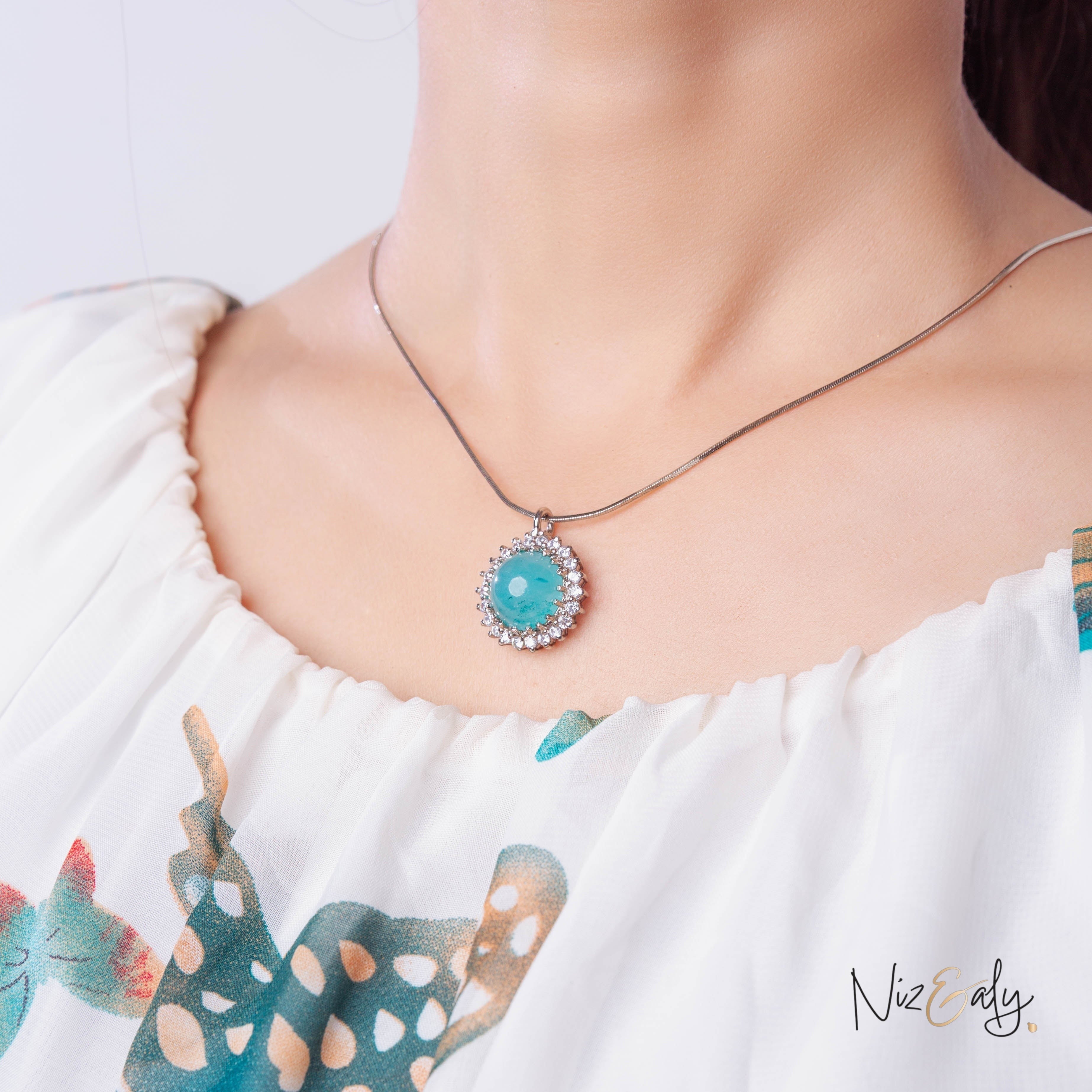 Niz & Aly amazonite pendant featuring a round blue-green gemstone surrounded by sparkling crystals on a silver chain