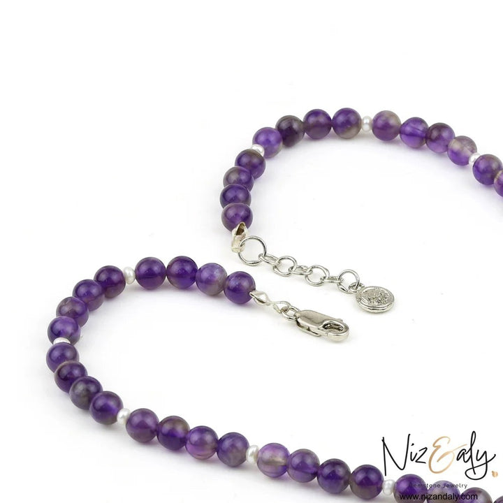 Niz & Aly amethyst beaded necklace with small white pearl accents and silver clasp detail on white background