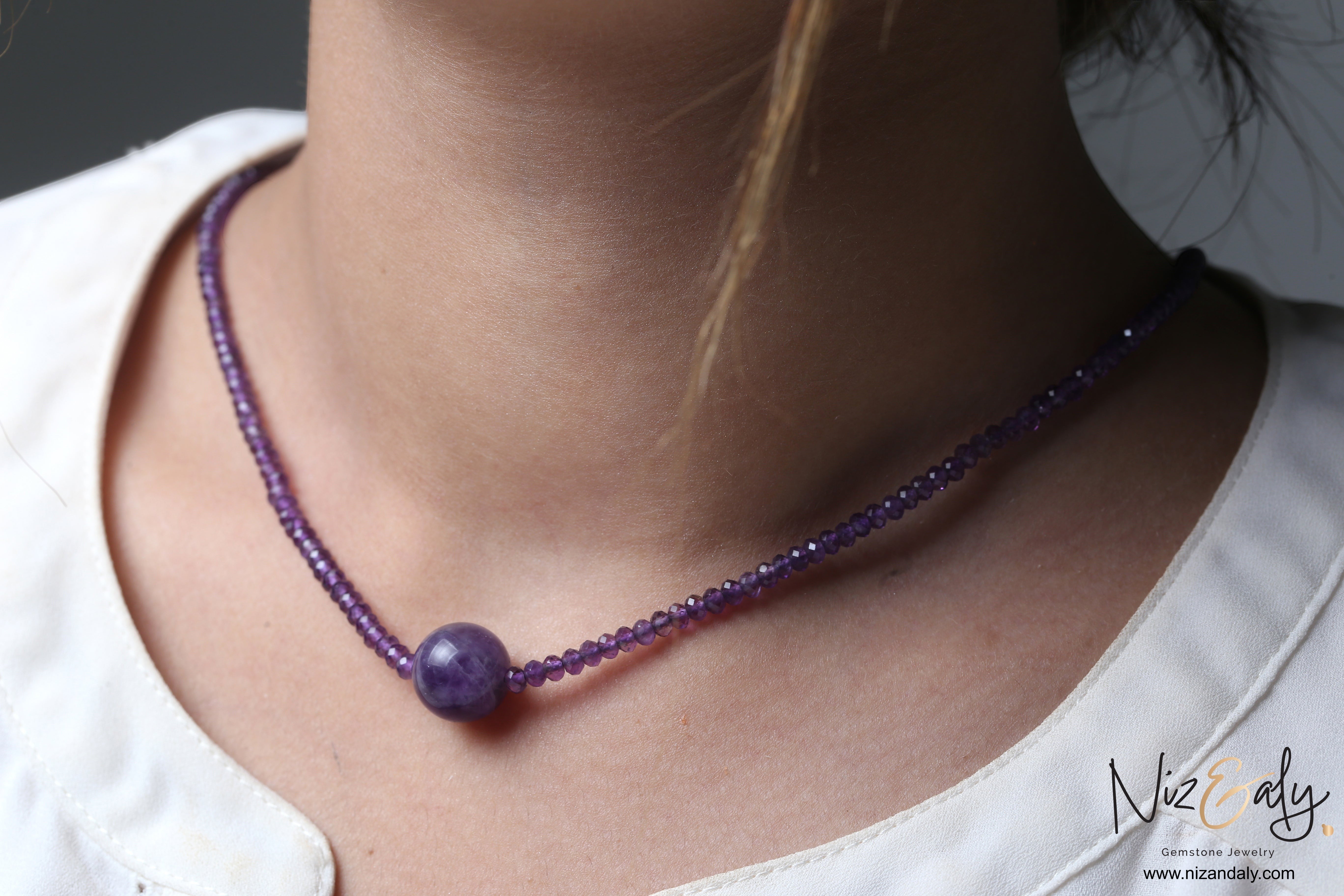 Niz & Aly Celestial Dew necklace featuring a central smooth amethyst sphere on a strand of faceted purple beads