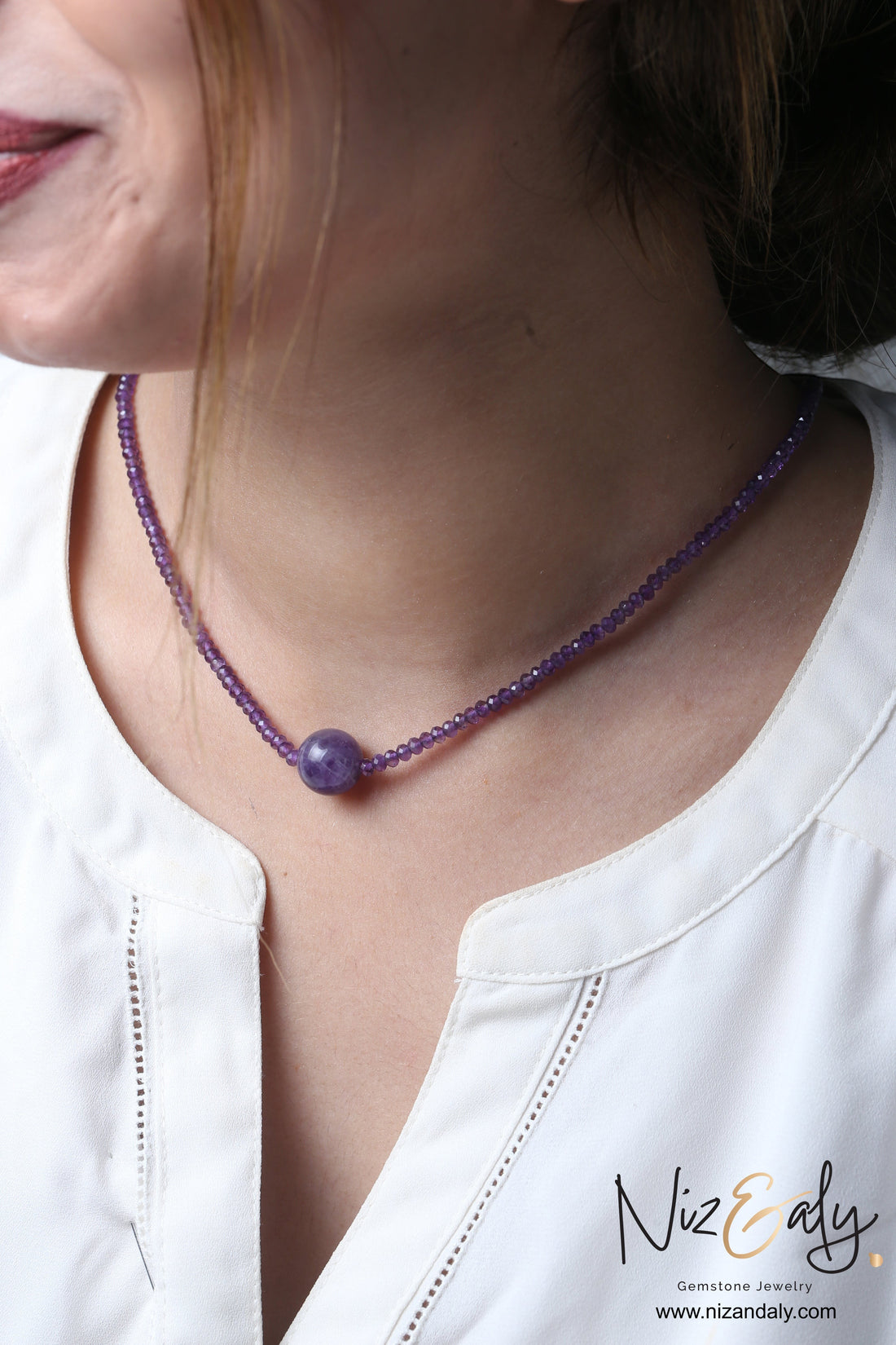 Niz & Aly Celestial Dew amethyst necklace featuring a central smooth sphere bead on a strand of faceted purple beads.