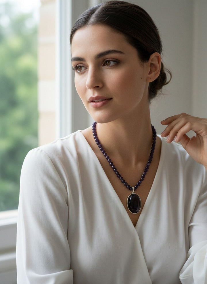 Niz & Aly amethyst gemstone necklace featuring a polished oval pendant on a strand of natural purple amethyst beads.
