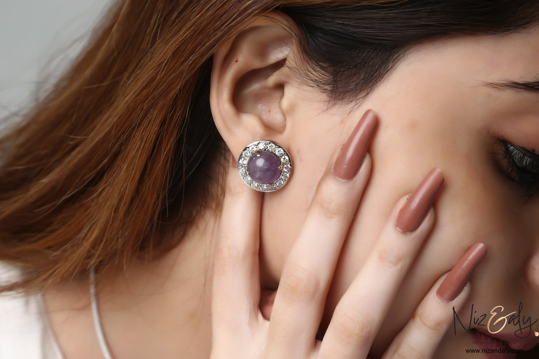 Niz & Aly amethyst constellation earring with a round purple gemstone and sparkling star-like accents on a model