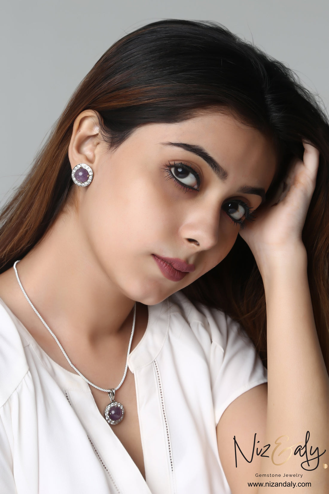 Niz & Aly amethyst constellation pendant and earring set worn by a woman with long brown hair