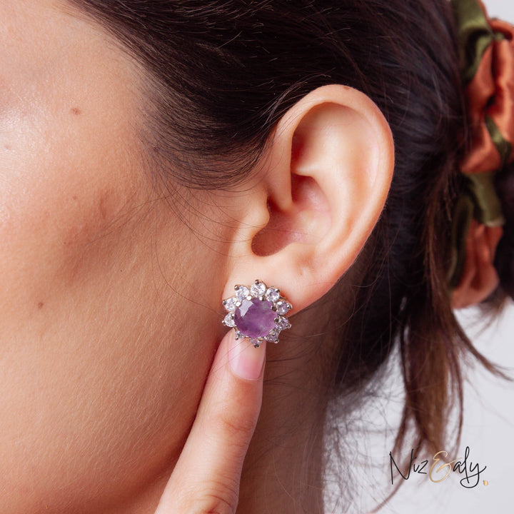 Niz & Aly amethyst and silver stud earring worn on a model, featuring a central violet stone with a floral halo.