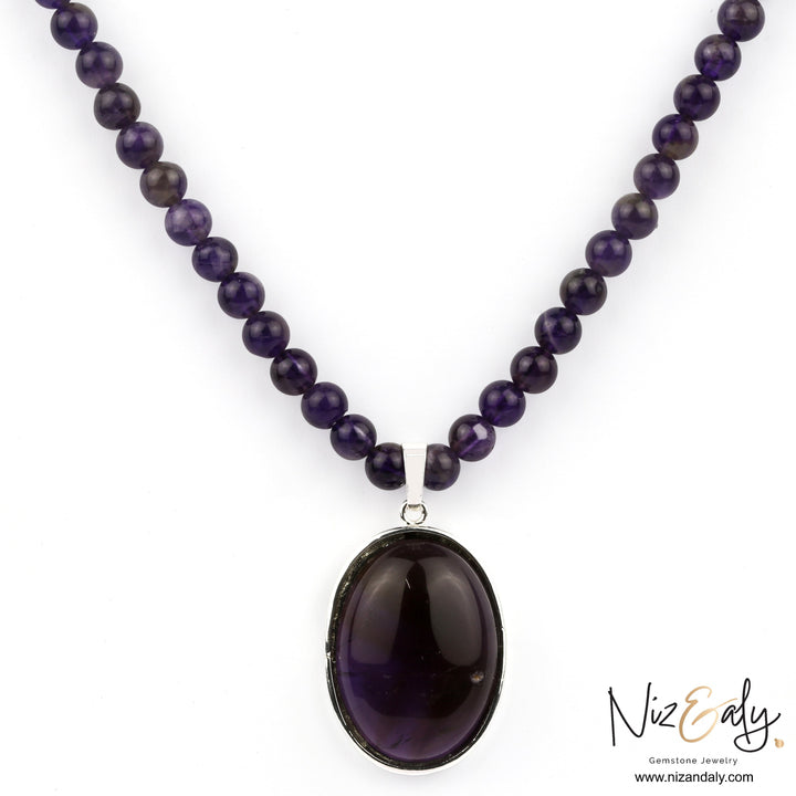 Niz & Aly amethyst gemstone necklace featuring a polished oval pendant on a strand of natural purple amethyst beads.