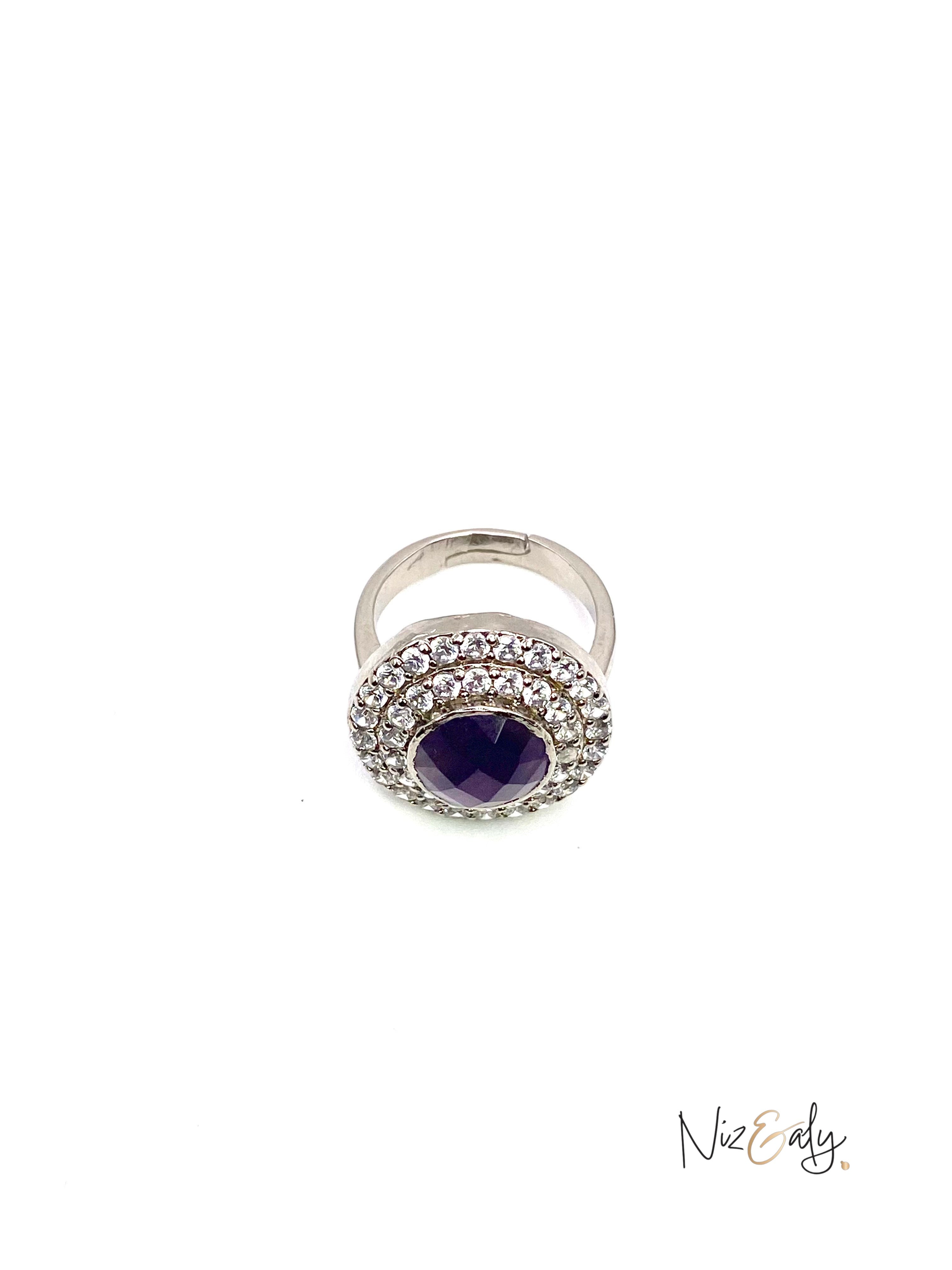 Niz & Aly amethyst hemisphere ring with a deep violet stone surrounded by a halo of sparkling crystals on a silver band