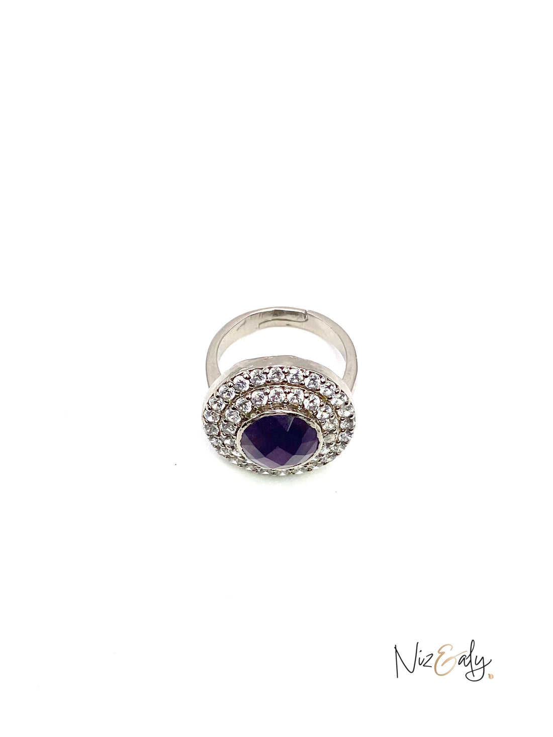 Niz & Aly amethyst hemisphere ring with a deep violet stone surrounded by a halo of sparkling crystals on a silver band