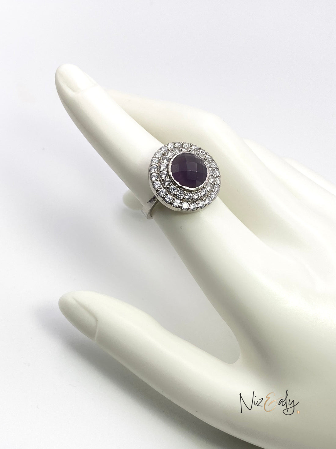 Niz & Aly Amethyst in Hemisphere Ring featuring a deep violet dome stone surrounded by a halo of sparkling crystals.