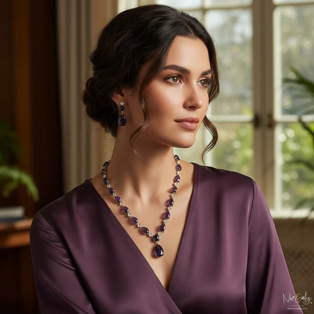 Niz & Aly droplet amethyst and Herkimer diamond necklace and earring set worn by a woman in a purple silk dress.