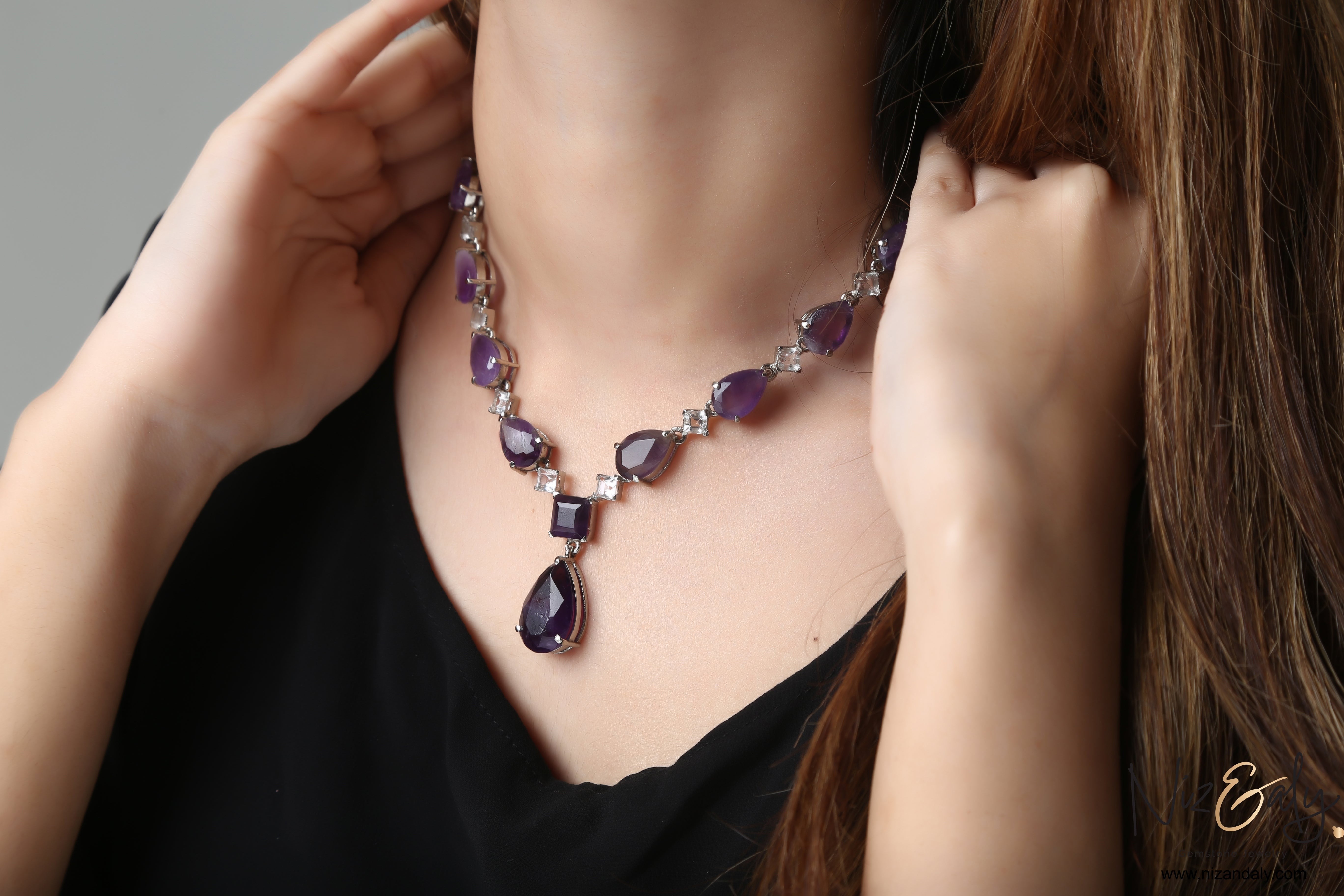 Niz & Aly droplet amethyst and Herkimer diamond necklace worn by a woman, featuring purple gemstones and clear quartz.