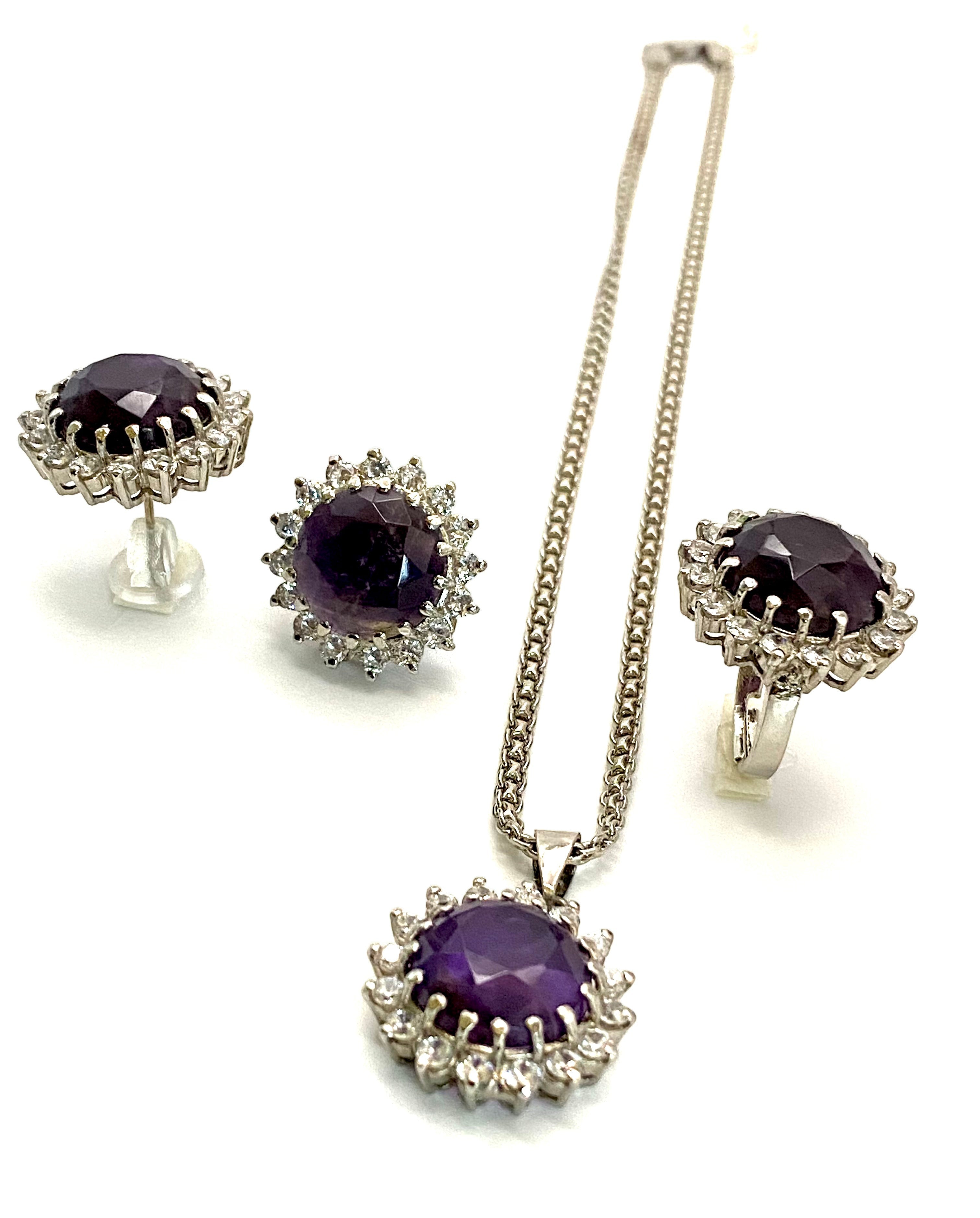 Niz & Aly Amethyst Serenity Locket Set featuring a silver necklace, ring, and stud earrings with purple gemstones.