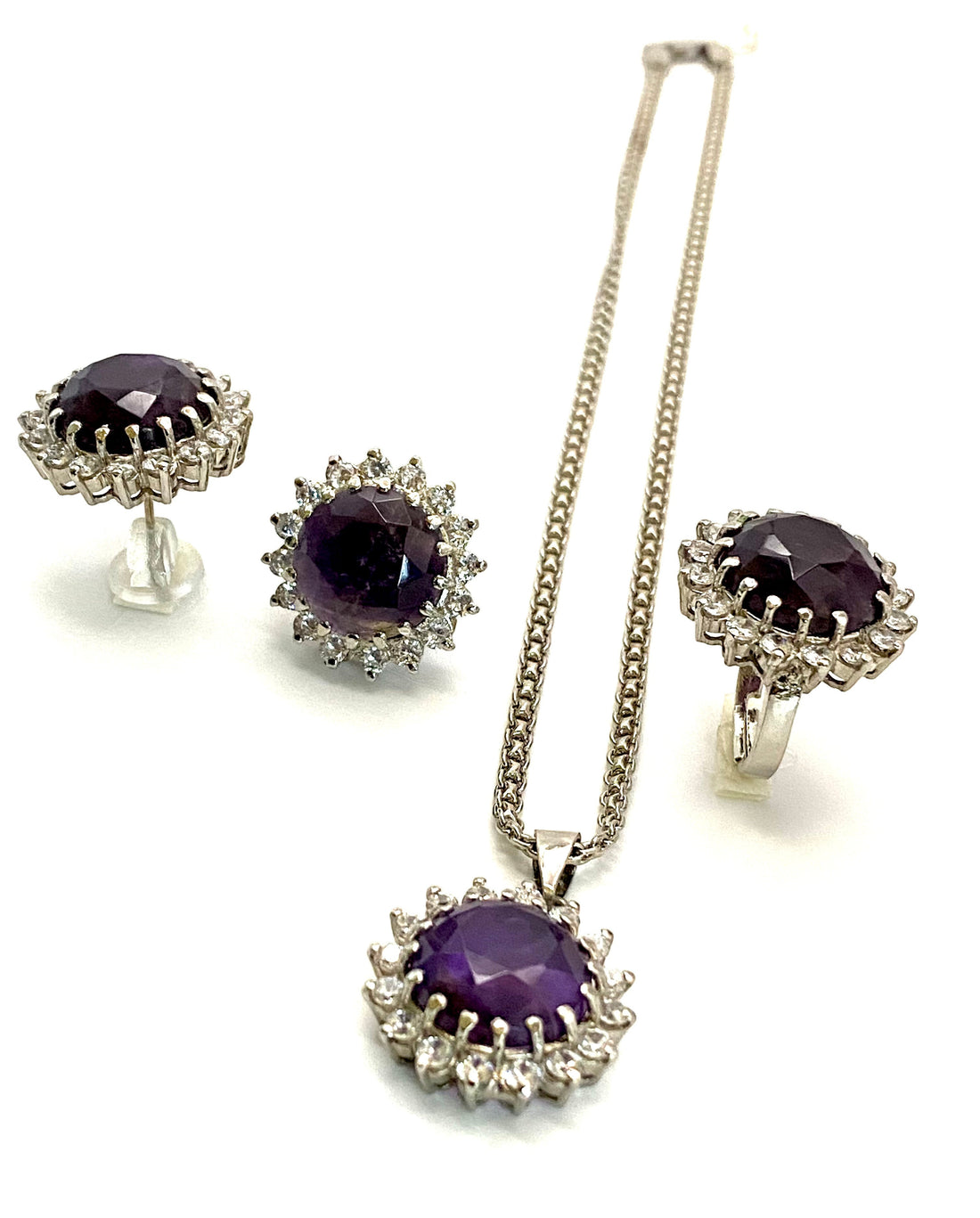 Niz & Aly Amethyst Serenity Locket Set featuring a silver necklace, ring, and stud earrings with purple gemstones.