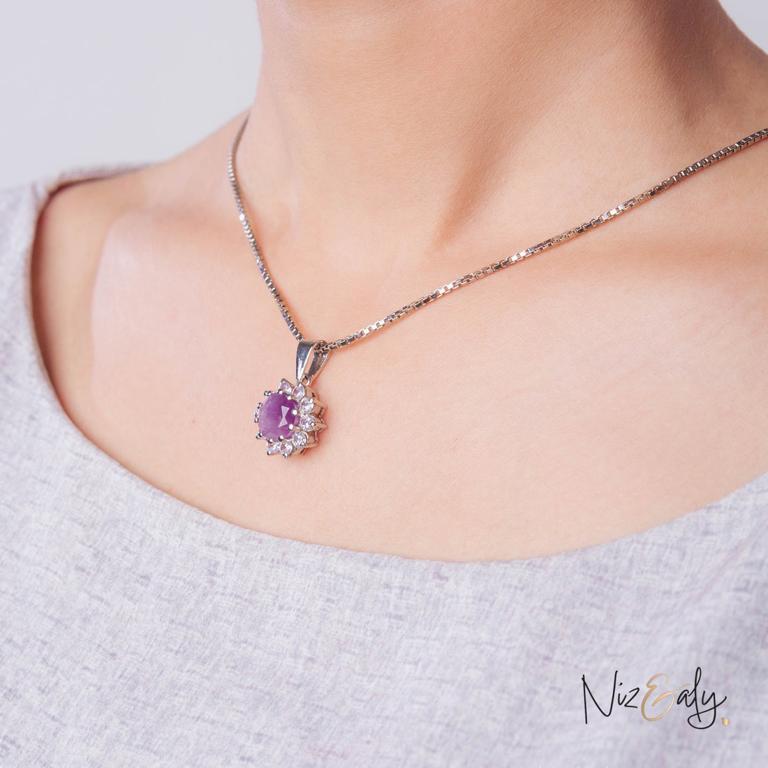 Niz & Aly amethyst locket pendant with a deep violet stone and clear accent crystals on a silver chain