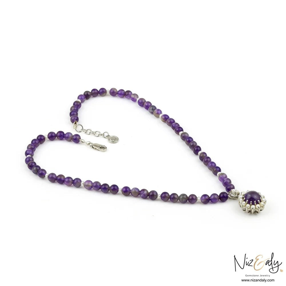 Niz & Aly amethyst beaded necklace featuring a central amethyst and pearl pendant in a silver setting.