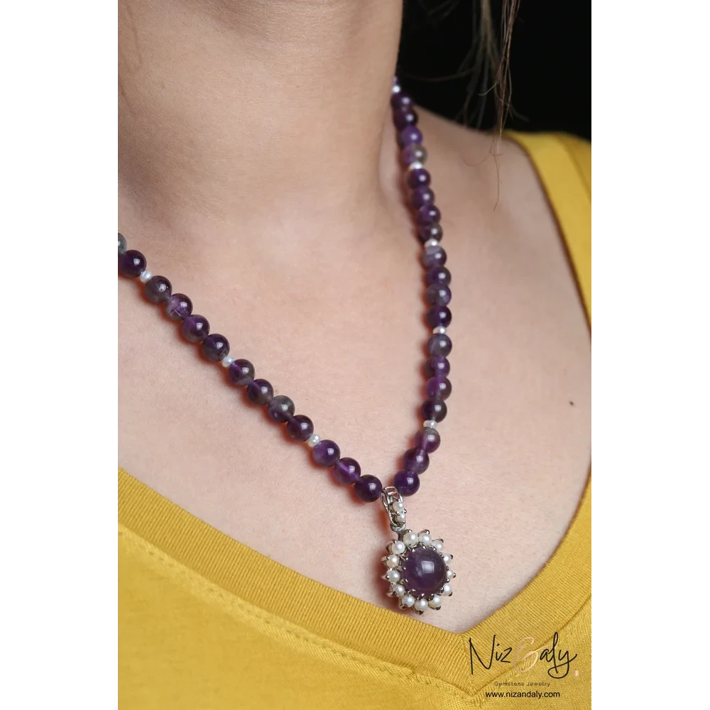 Niz & Aly amethyst and pearl pendant necklace with purple beaded strand worn on a model in a yellow top