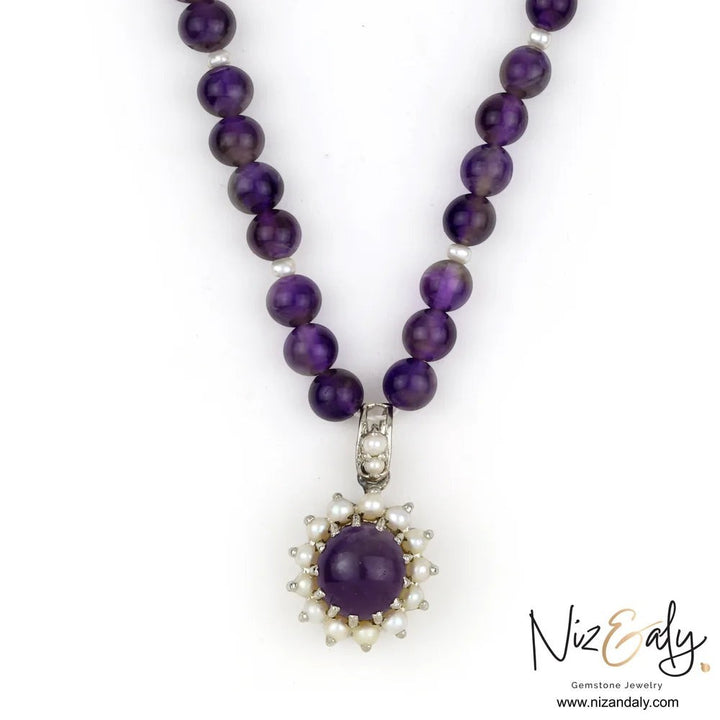 Niz & Aly amethyst and pearl pendant necklace featuring a round purple gemstone surrounded by small white pearls