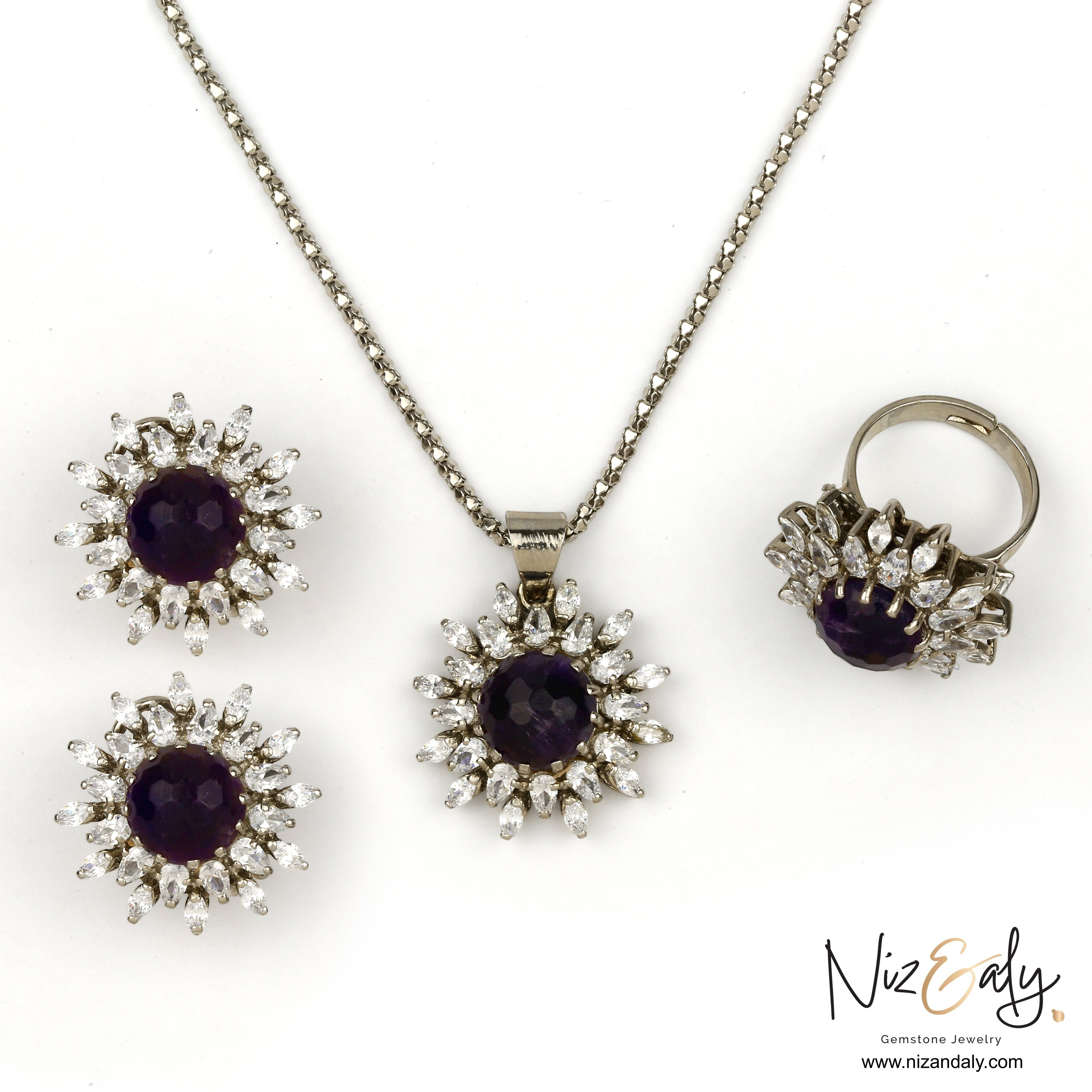 Niz & Aly amethyst pendant set with matching earrings and ring featuring deep purple stones and clear crystal halos.