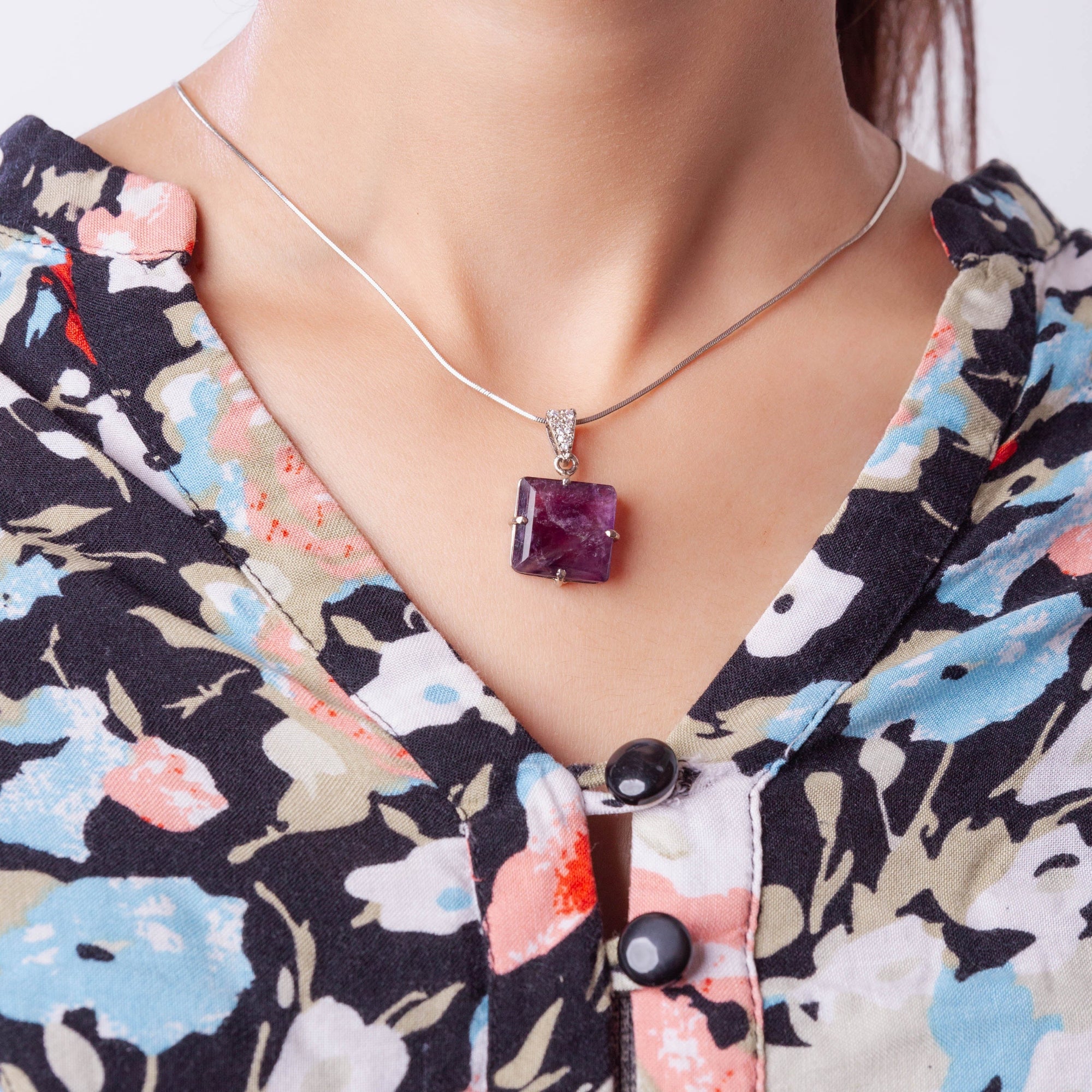 Niz & Aly square-cut amethyst locket pendant on a silver chain worn around a model's neck.