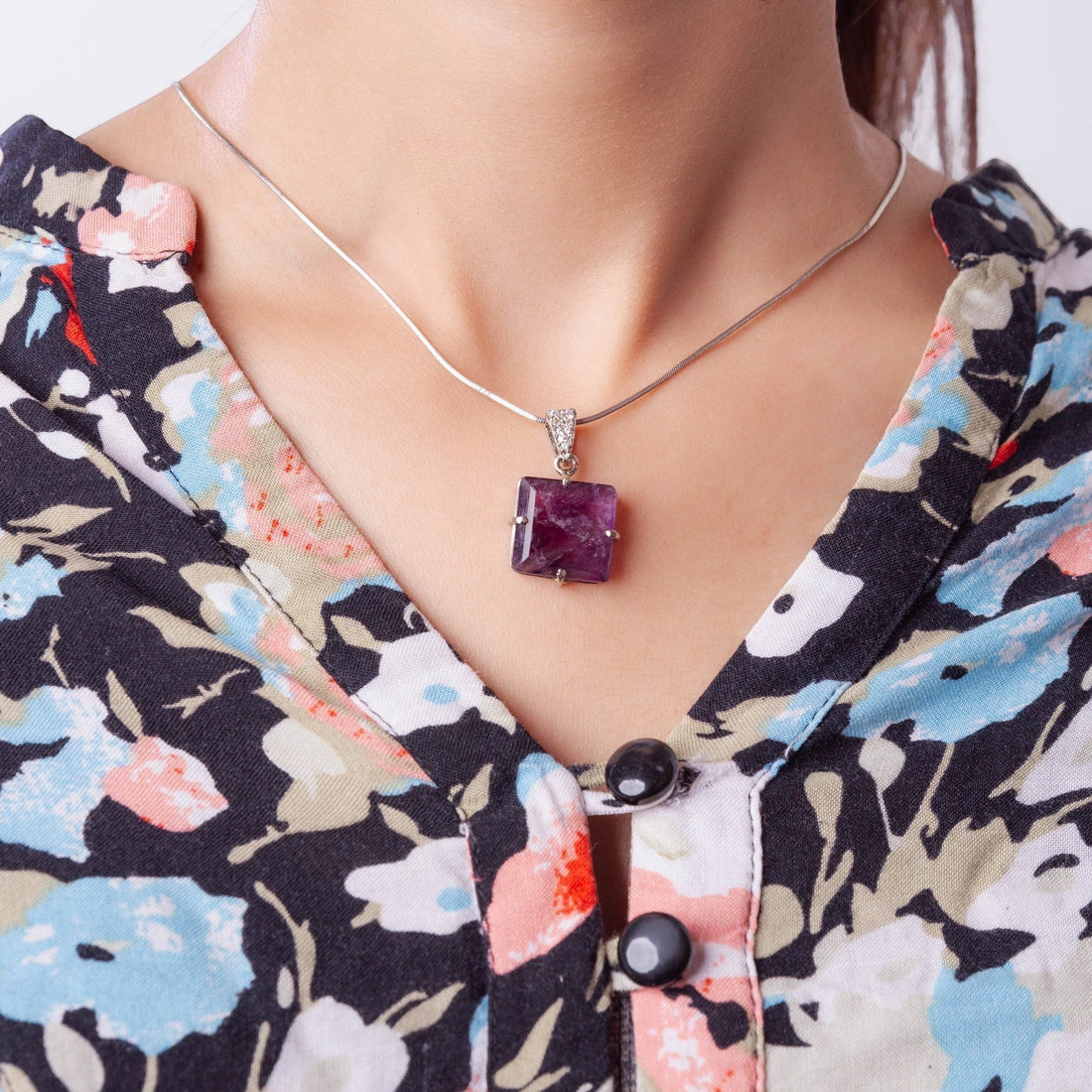 Niz & Aly square-cut amethyst locket pendant on a silver chain worn around a model's neck.