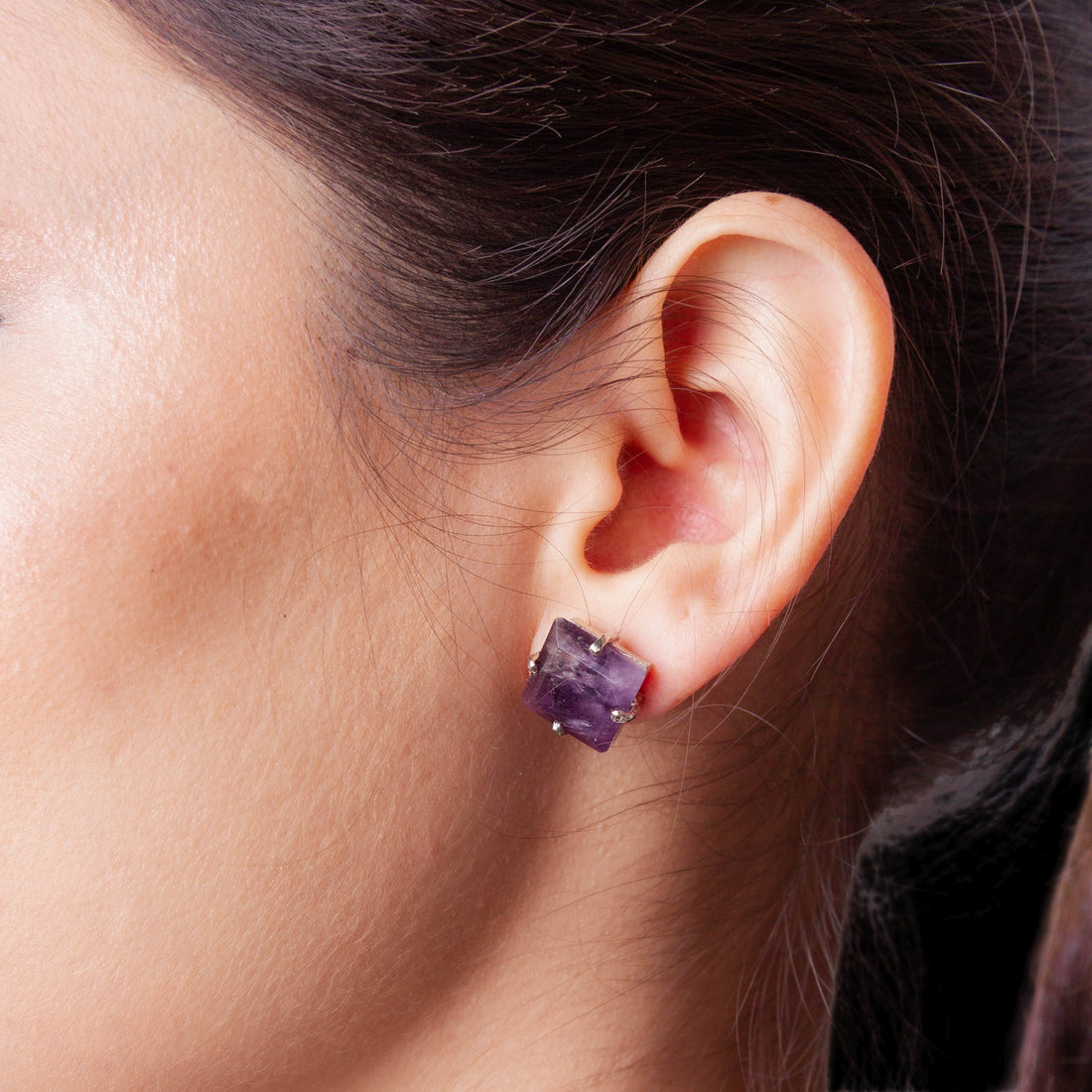 Niz & Aly square-cut amethyst stud earring worn on a model, featuring a deep violet stone in a modern setting.