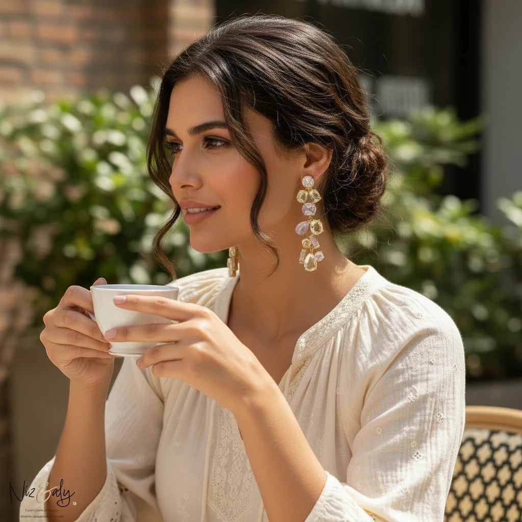 Niz & Aly natural ametrine and citrine dangle drop earrings worn by a woman holding a coffee cup outdoors.