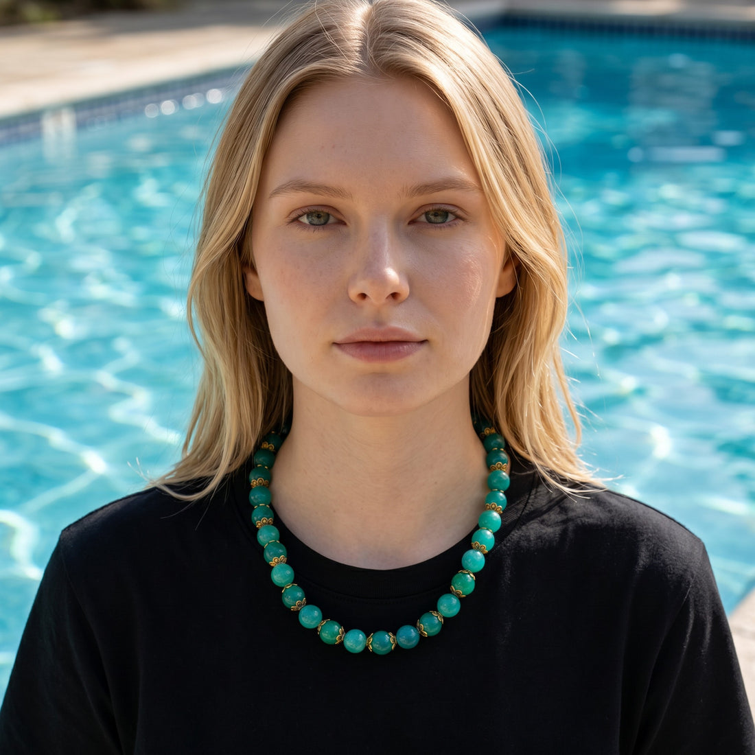Niz & Aly aqua chalcedony beaded necklace with gold accents worn by a woman against a blue swimming pool background