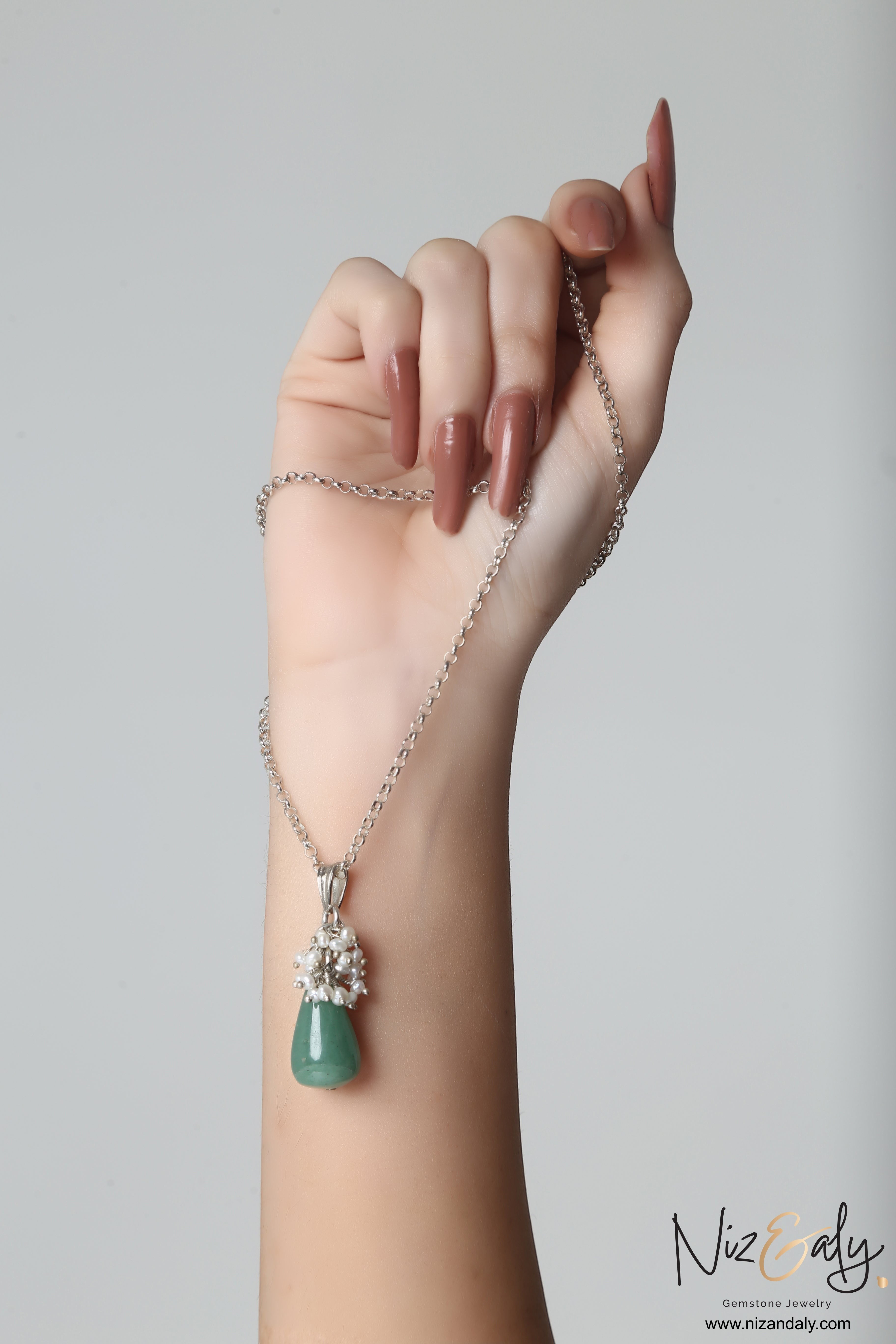 Niz & Aly dainty green aventurine and freshwater pearl drop pendant necklace held in a hand