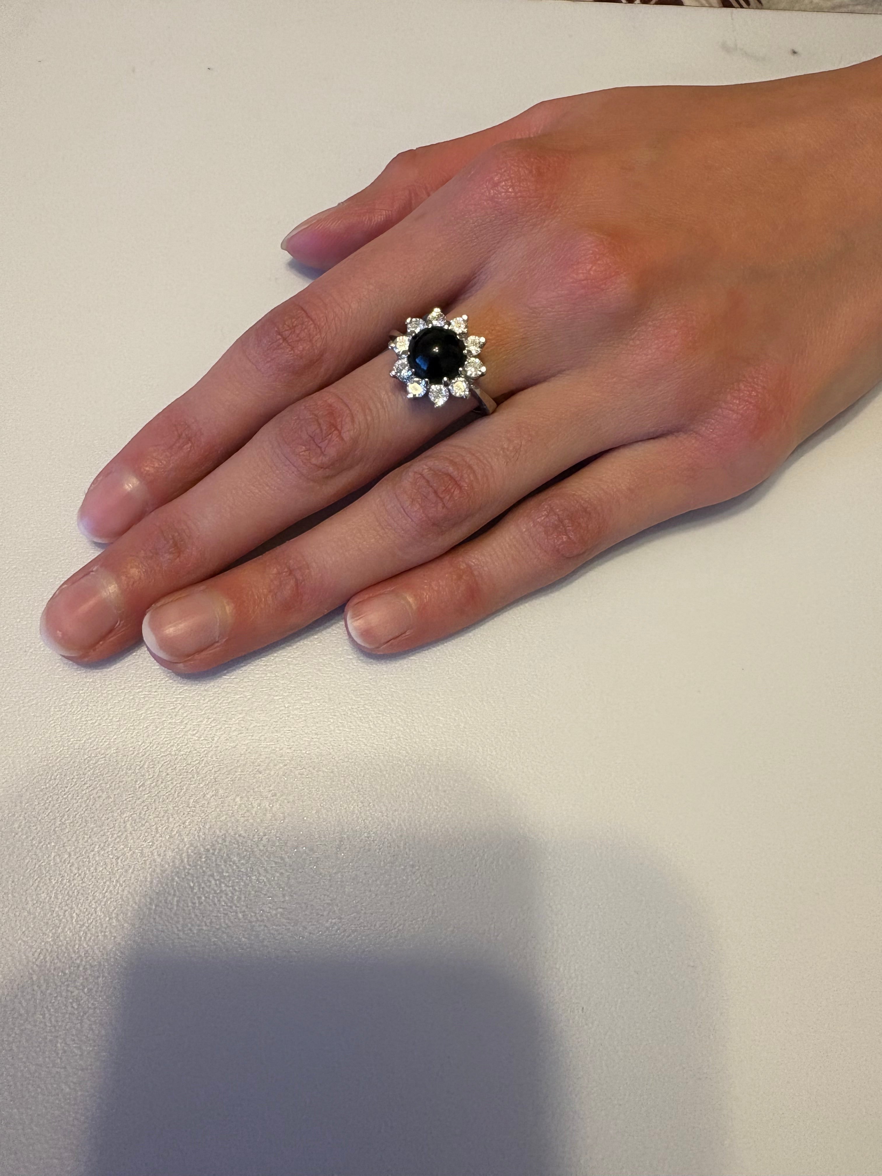 Niz & Aly natural black onyx ring with a halo of sparkling stones on a woman's finger, elegant adjustable band.