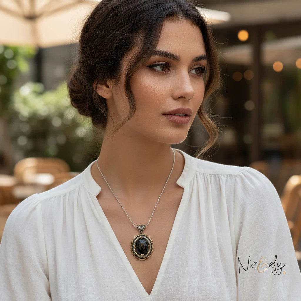 Niz & Aly faceted black onyx pendant necklace with VVS cubic zirconia stones worn by a woman in a white blouse