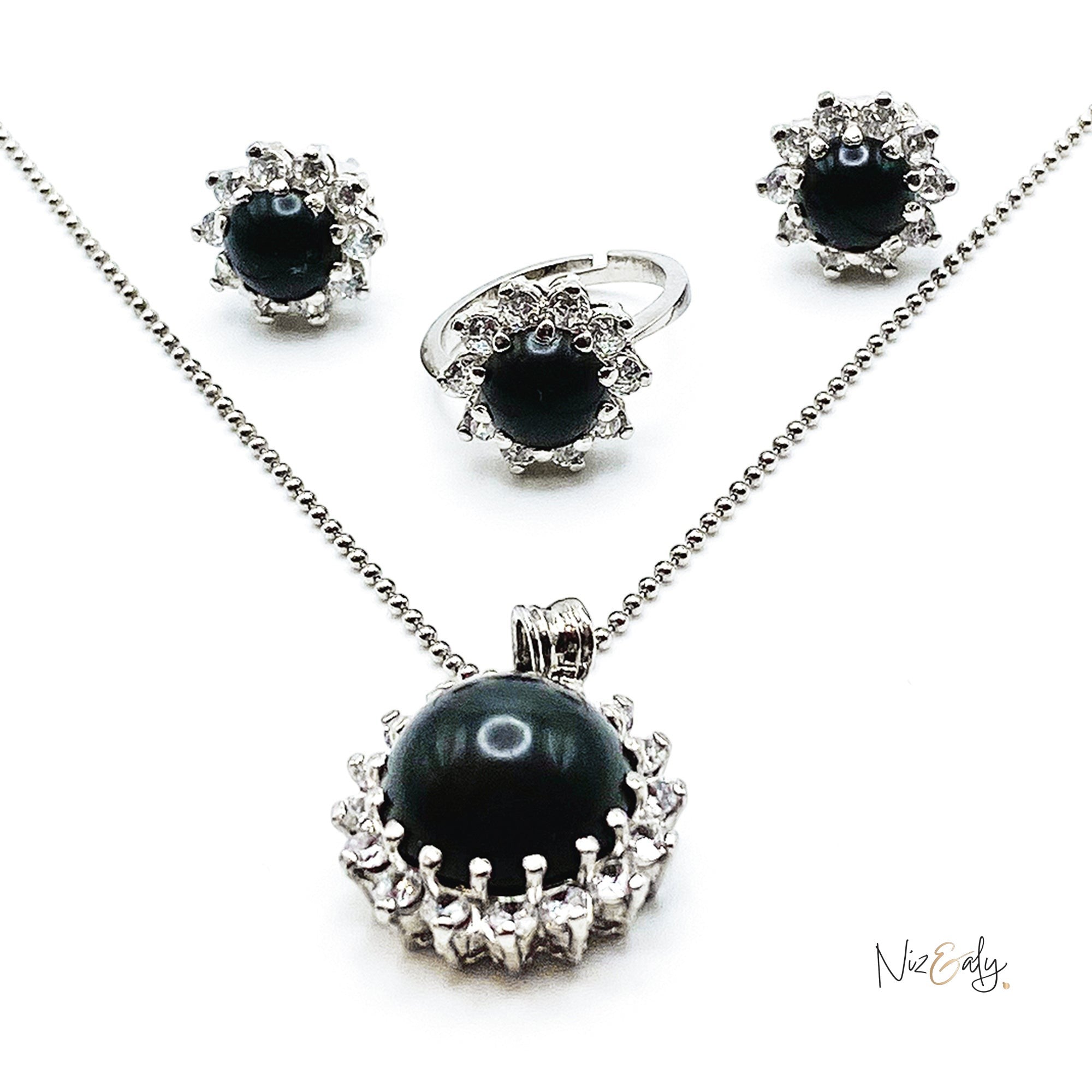 Niz & Aly pendant set featuring a black onyx cabochon stone surrounded by sparkling cubic zirconia in silver tone