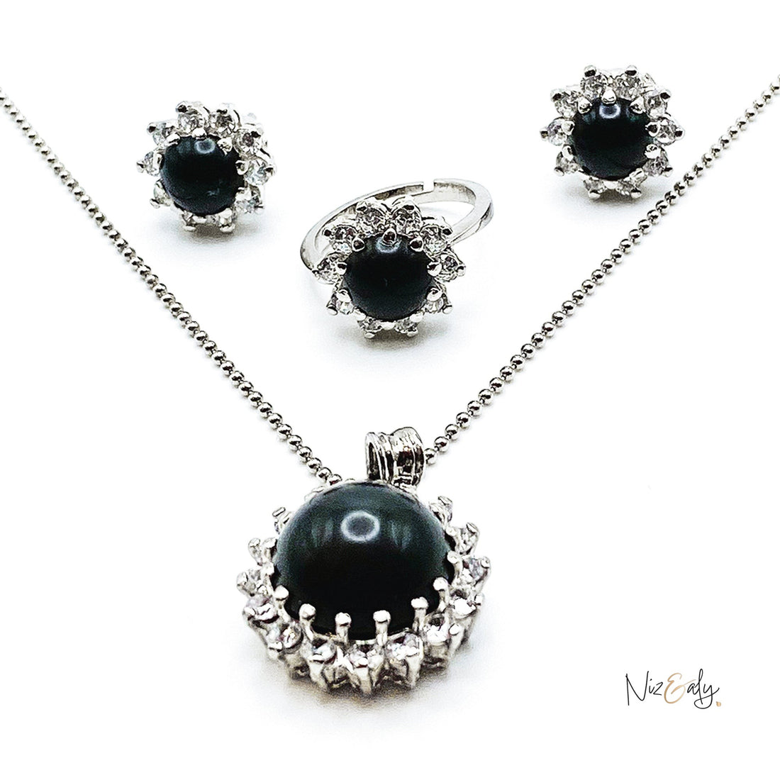Niz & Aly pendant set featuring a black onyx cabochon stone surrounded by sparkling cubic zirconia in silver tone