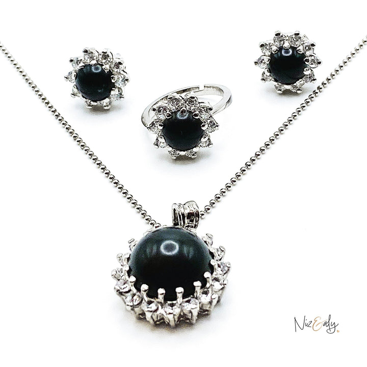 Niz & Aly pendant set featuring a black onyx cabochon stone surrounded by sparkling cubic zirconia in silver tone
