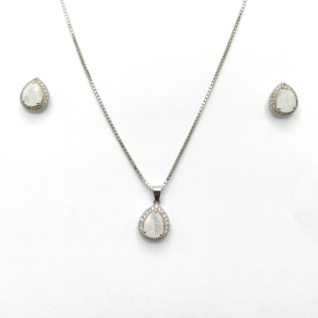Niz & Aly blue flash moonstone pendant and earring set with silver halo settings on a white background