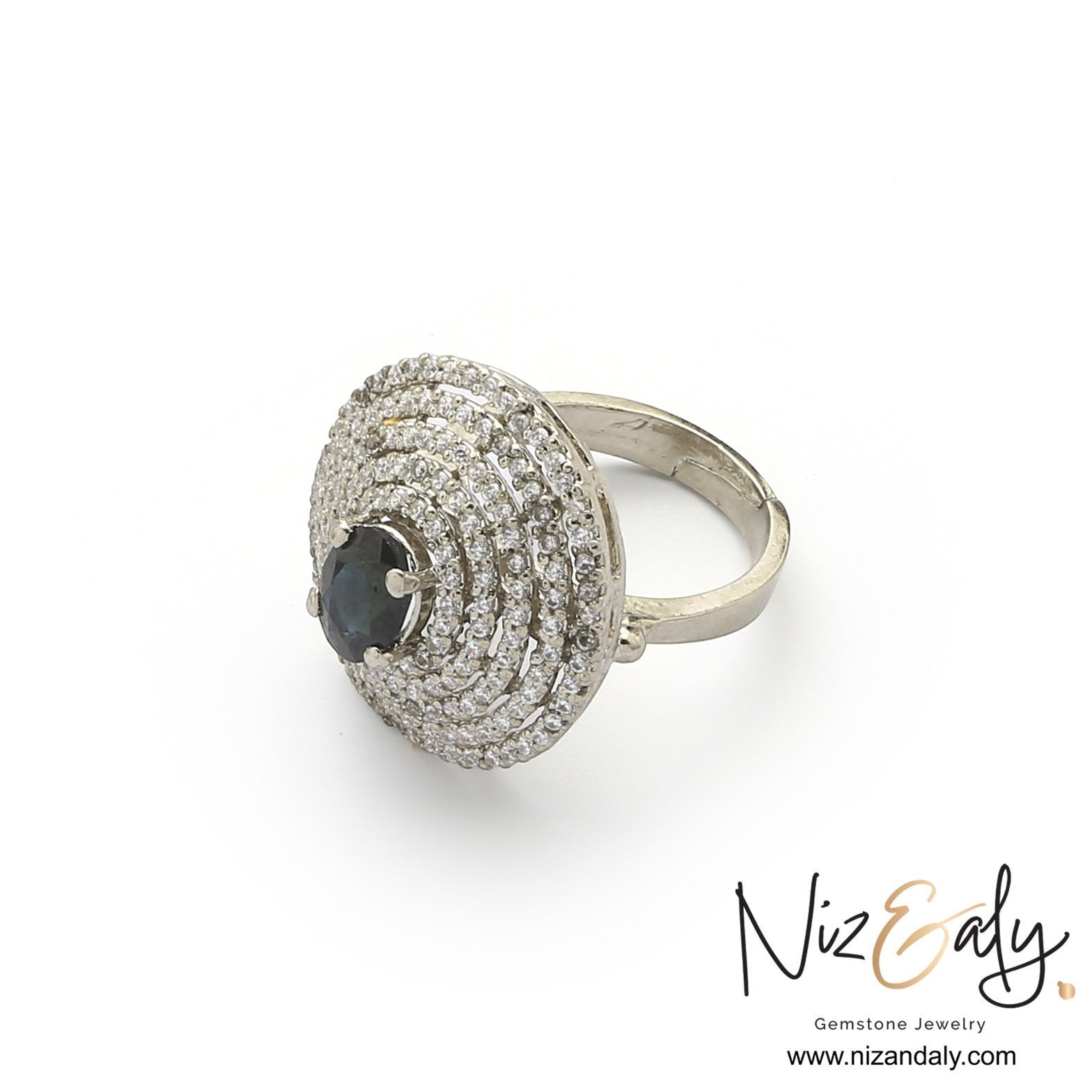 Niz & Aly celestial ring featuring a natural deep blue sapphire surrounded by concentric halos of shimmering stones.