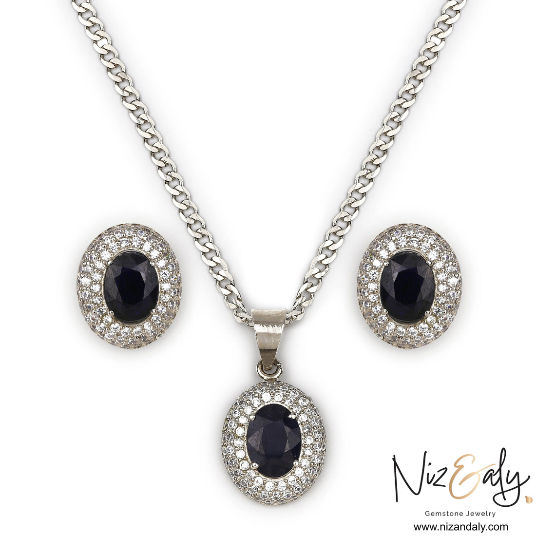 Niz & Aly royal blue sapphire pendant and stud earring set with diamond halo accents on a silver chain.