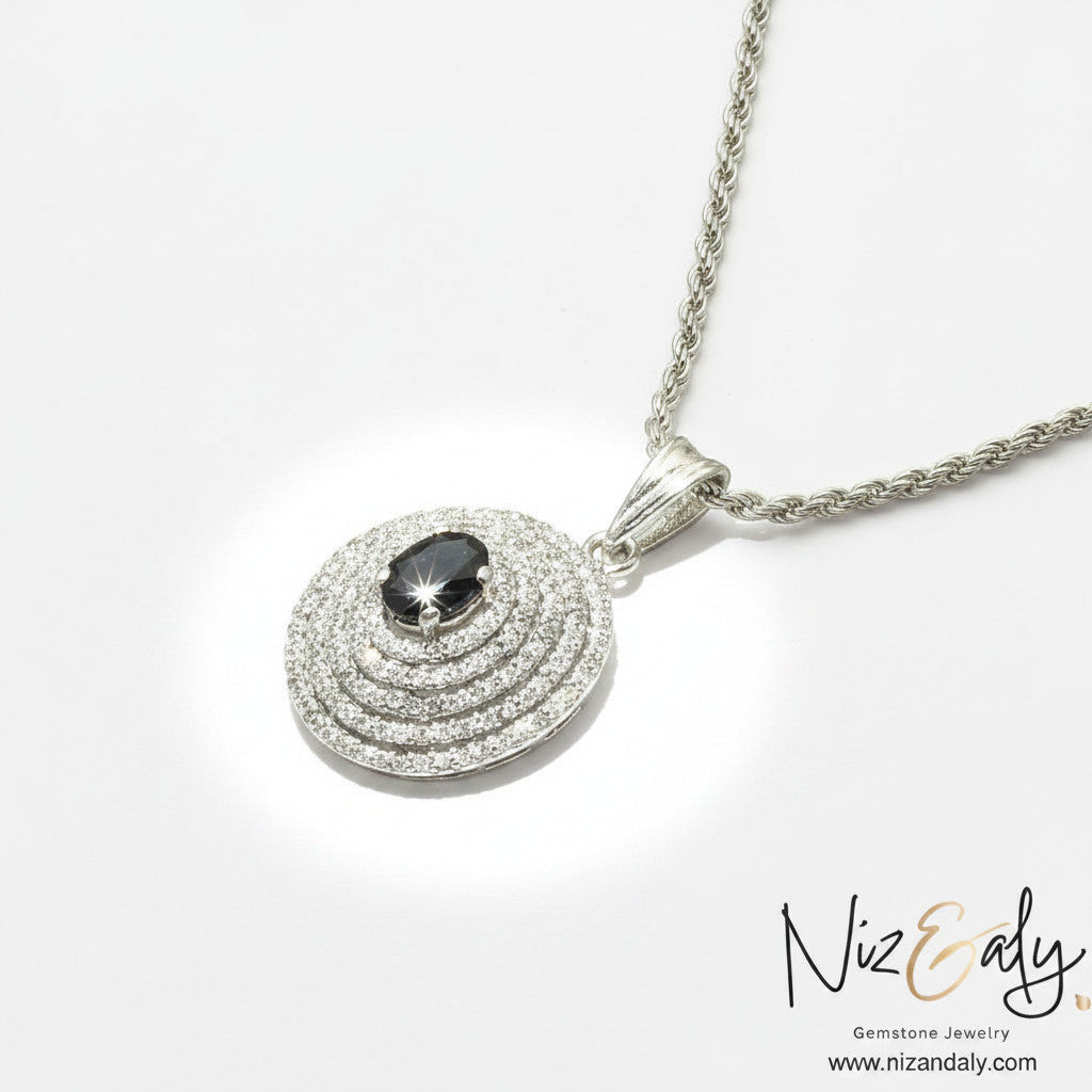 Niz & Aly Celestial Sapphire pendant necklace featuring a deep blue oval gemstone with concentric halos of diamonds.