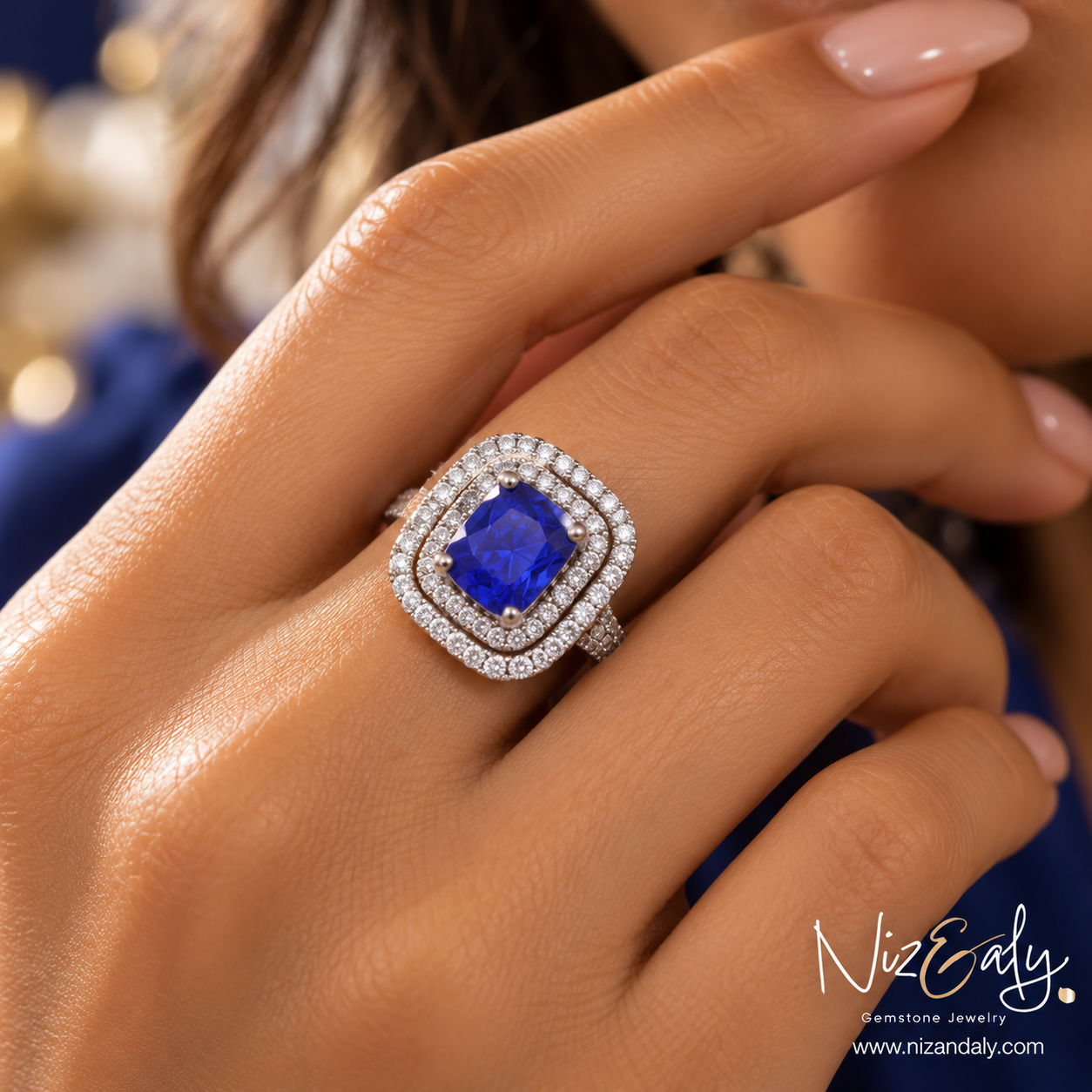 Niz & Aly sterling silver ring featuring a cushion-cut blue tanzanite stone with a double halo of sparkling diamonds.