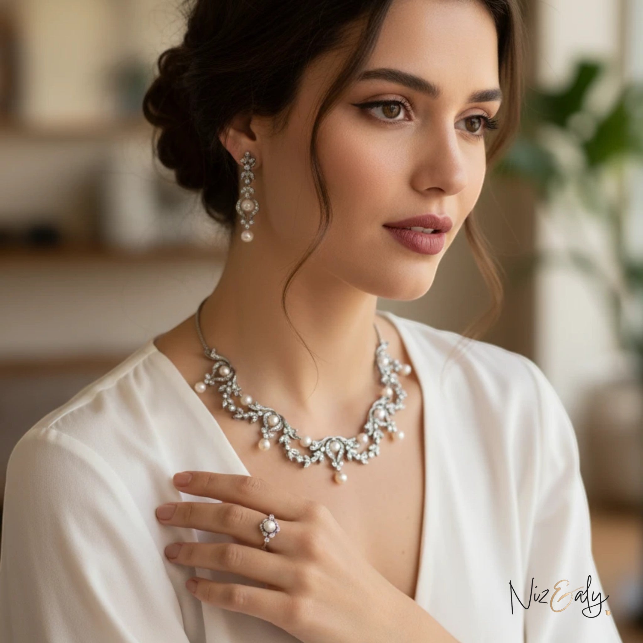 Niz & Aly bridal freshwater pearl necklace and earring set in sterling silver worn by a woman in a white dress.