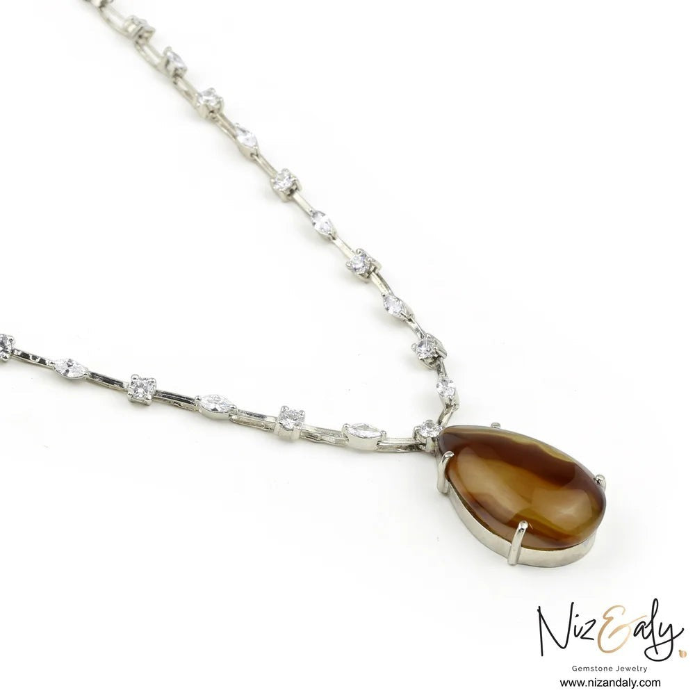 Niz & Aly brown agate teardrop pendant necklace with cubic zirconia studded chain on a white background