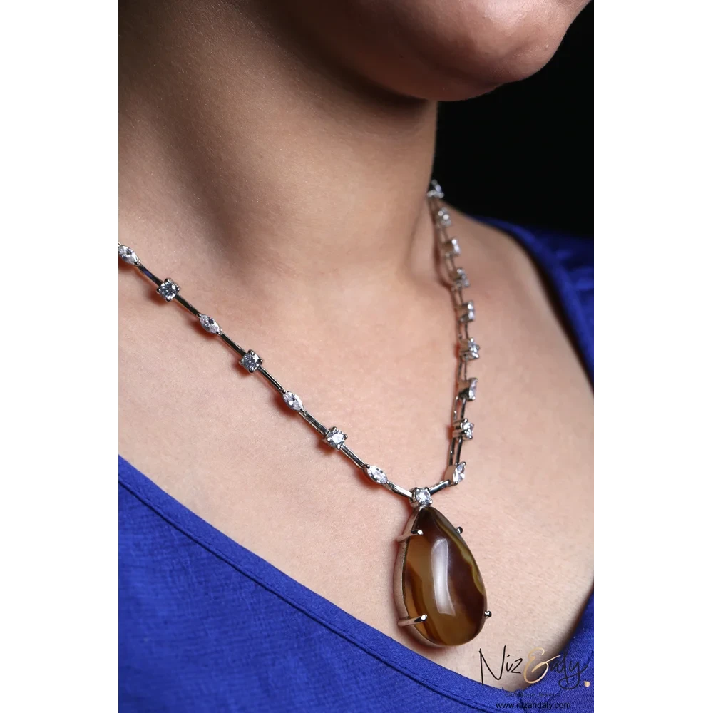 Niz & Aly brown agate teardrop pendant necklace with cubic zirconia studded chain on a model