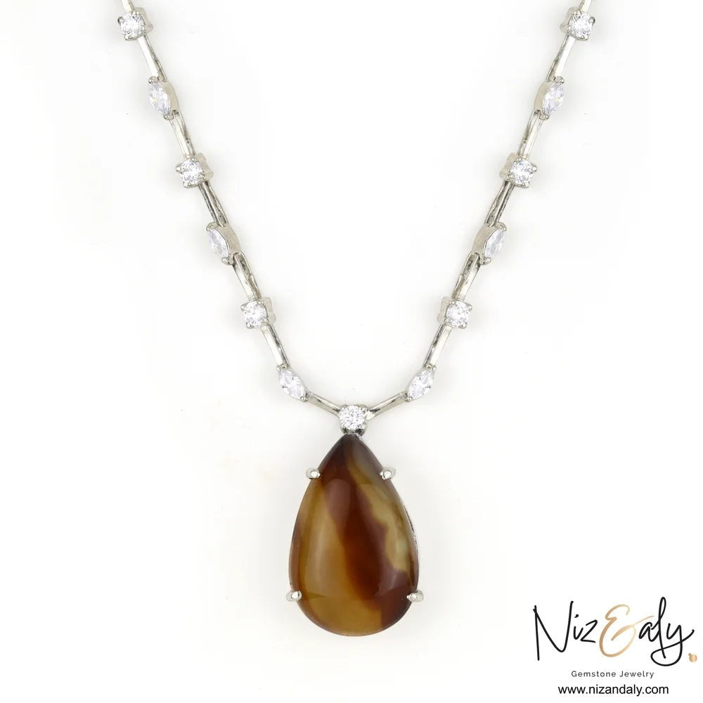 Niz & Aly brown agate teardrop pendant necklace with cubic zirconia studded silver chain on a white background
