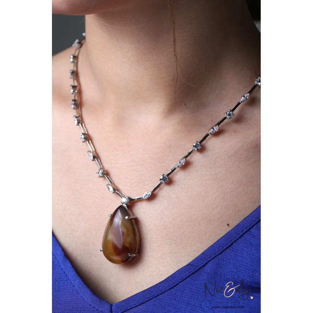 Niz & Aly brown agate teardrop pendant necklace with cubic zirconia studded chain worn on a model