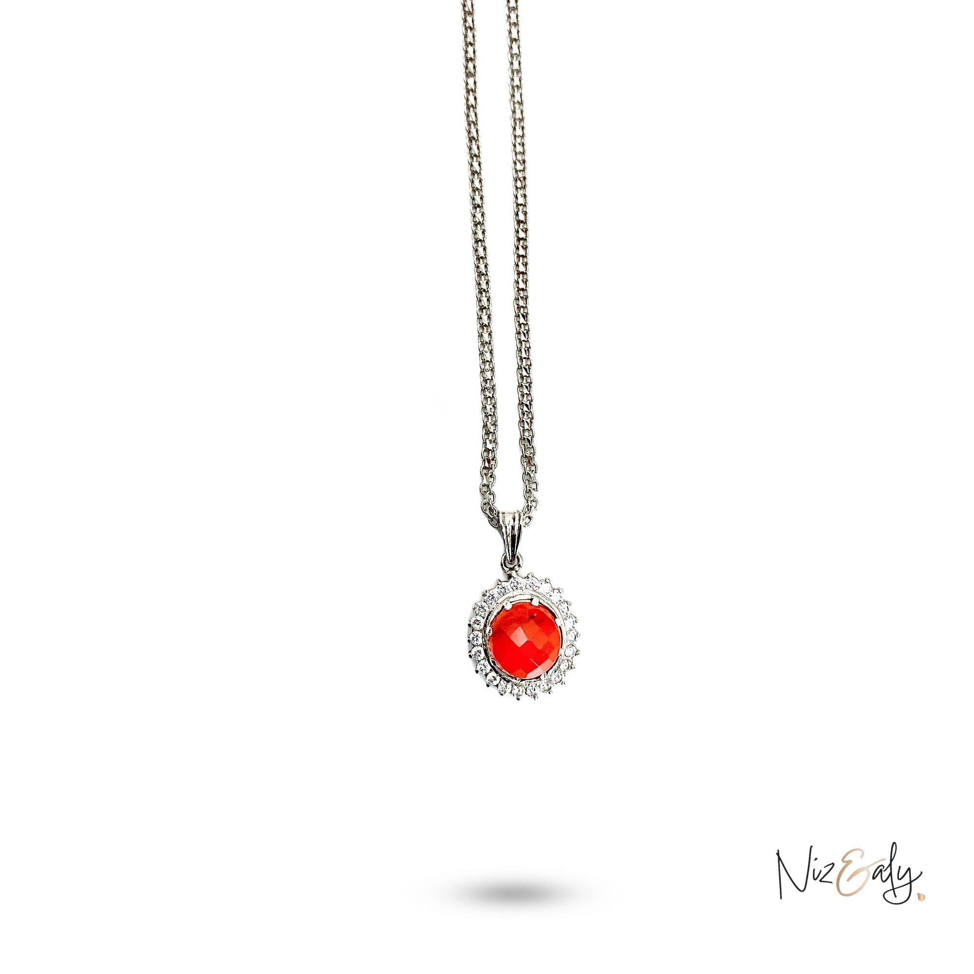 Niz & Aly radiant carnelian locket featuring a vibrant orange-red stone surrounded by a halo of sparkling crystals
