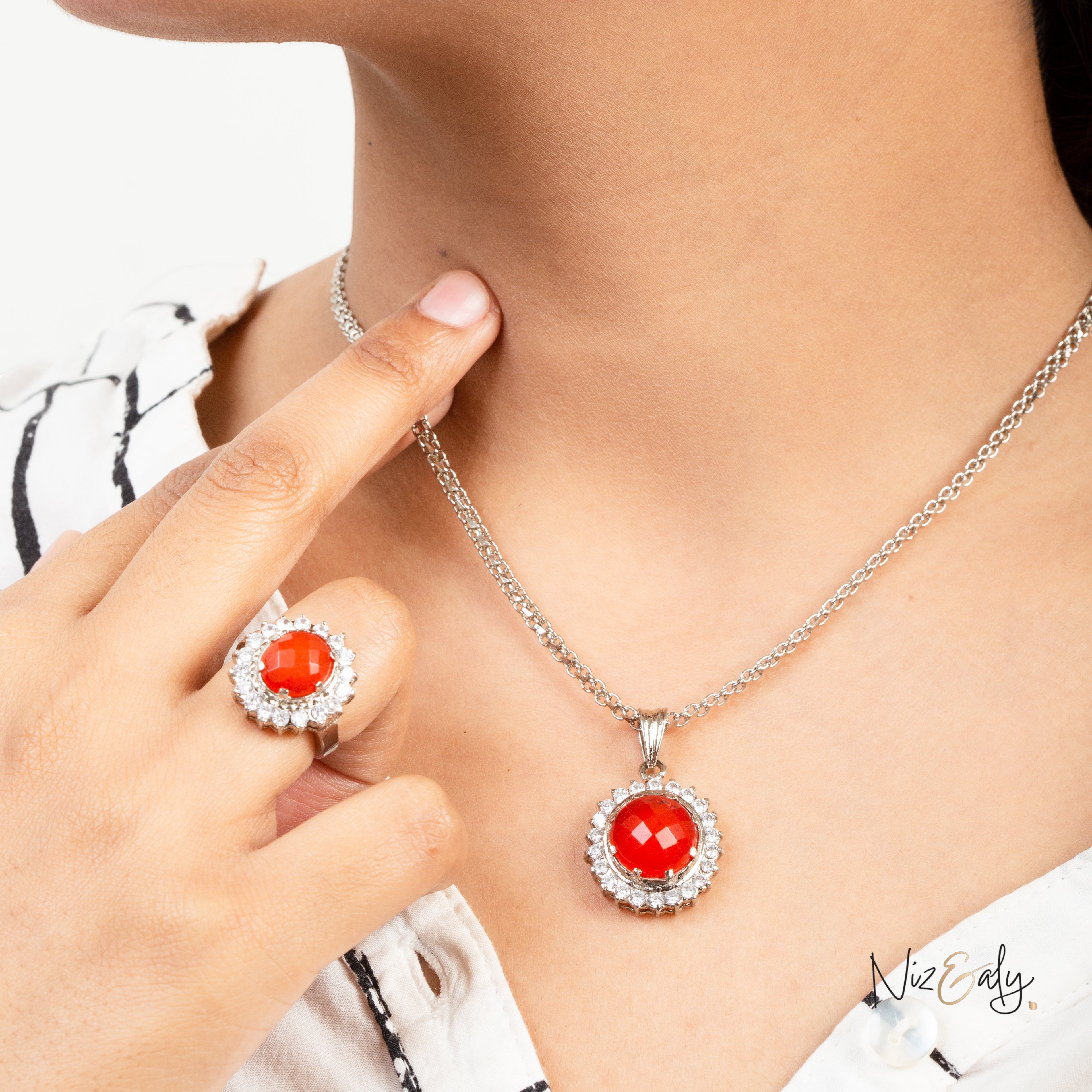 Niz & Aly Radiant Carnelian Locket Set featuring a vibrant orange-red stone pendant and matching ring on a model