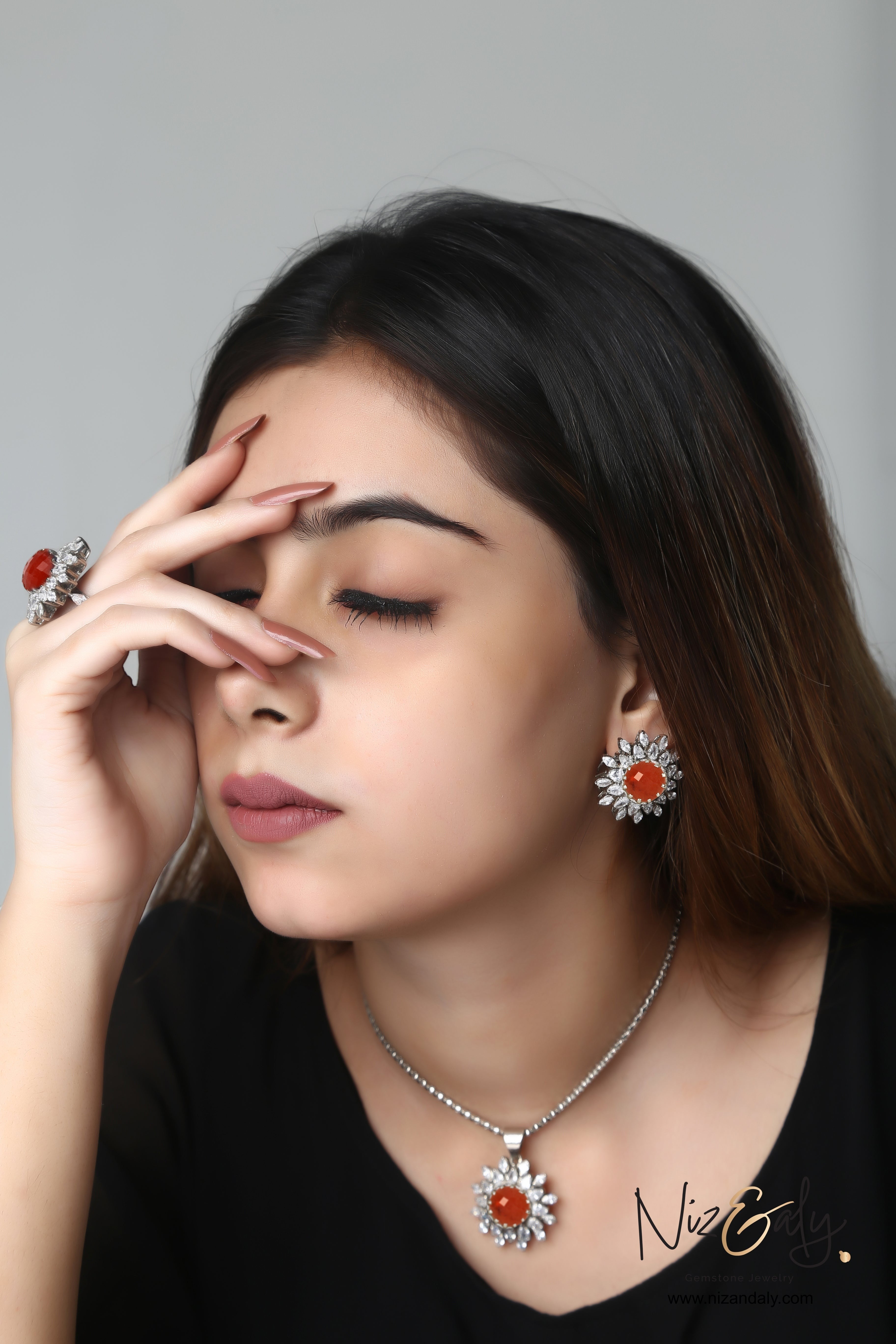 Niz & Aly faceted carnelian and quartz pendant set with matching floral earrings and ring worn by a model
