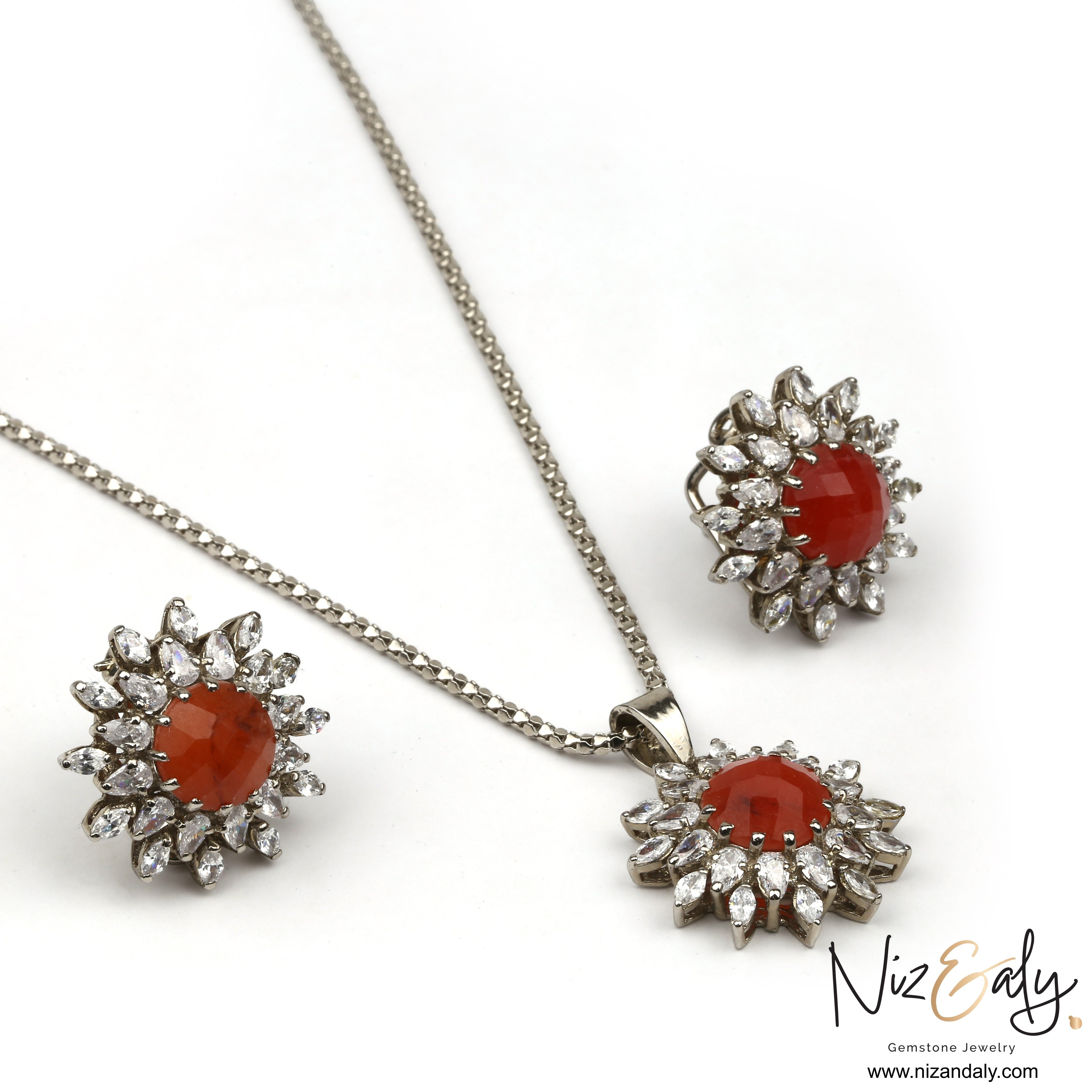 Niz & Aly faceted carnelian and quartz pendant and earring set with silver-tone floral halo design on white background