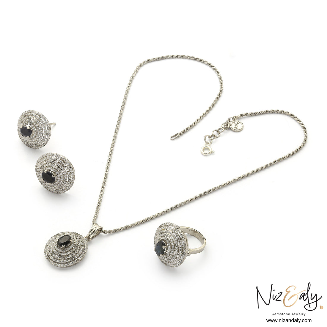 Niz & Aly Celestial Sapphire jewelry set featuring a pendant necklace, earrings, and ring with deep blue stones.