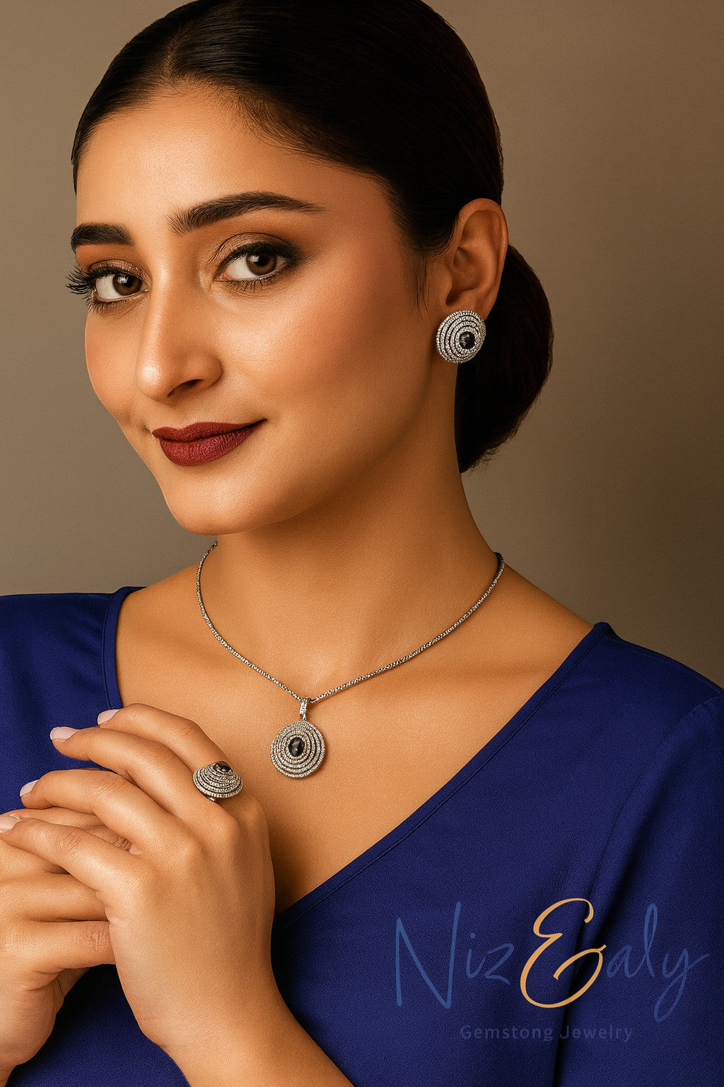 Niz & Aly Celestial Sapphire pendant necklace, earrings, and ring set with deep blue gemstones and shimmering halos.